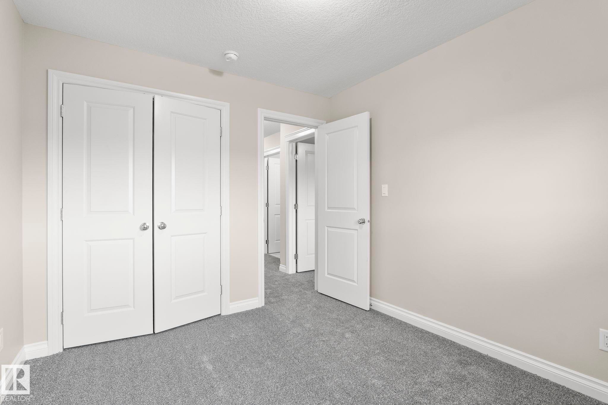 Room featuring light gray carpet, neutral wall paint, and white trim - 6927 Cardinal Wynd Sw, Edmonton, AB - Indoor Photo Showing Other Room