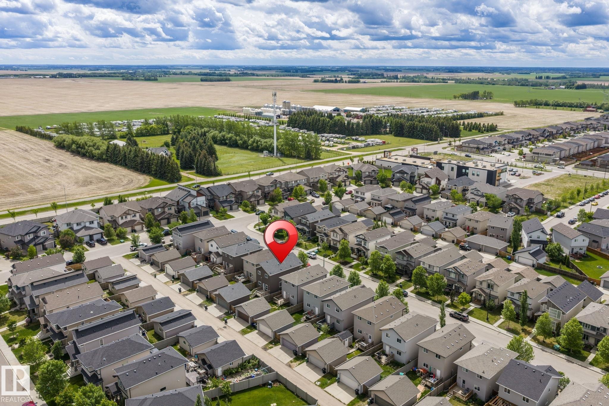 Residential neighborhood featuring a mix of detached homes and townhouses, paved streets, and mature landscaping - 6927 Cardinal Wynd Sw, Edmonton, AB - Outdoor With View