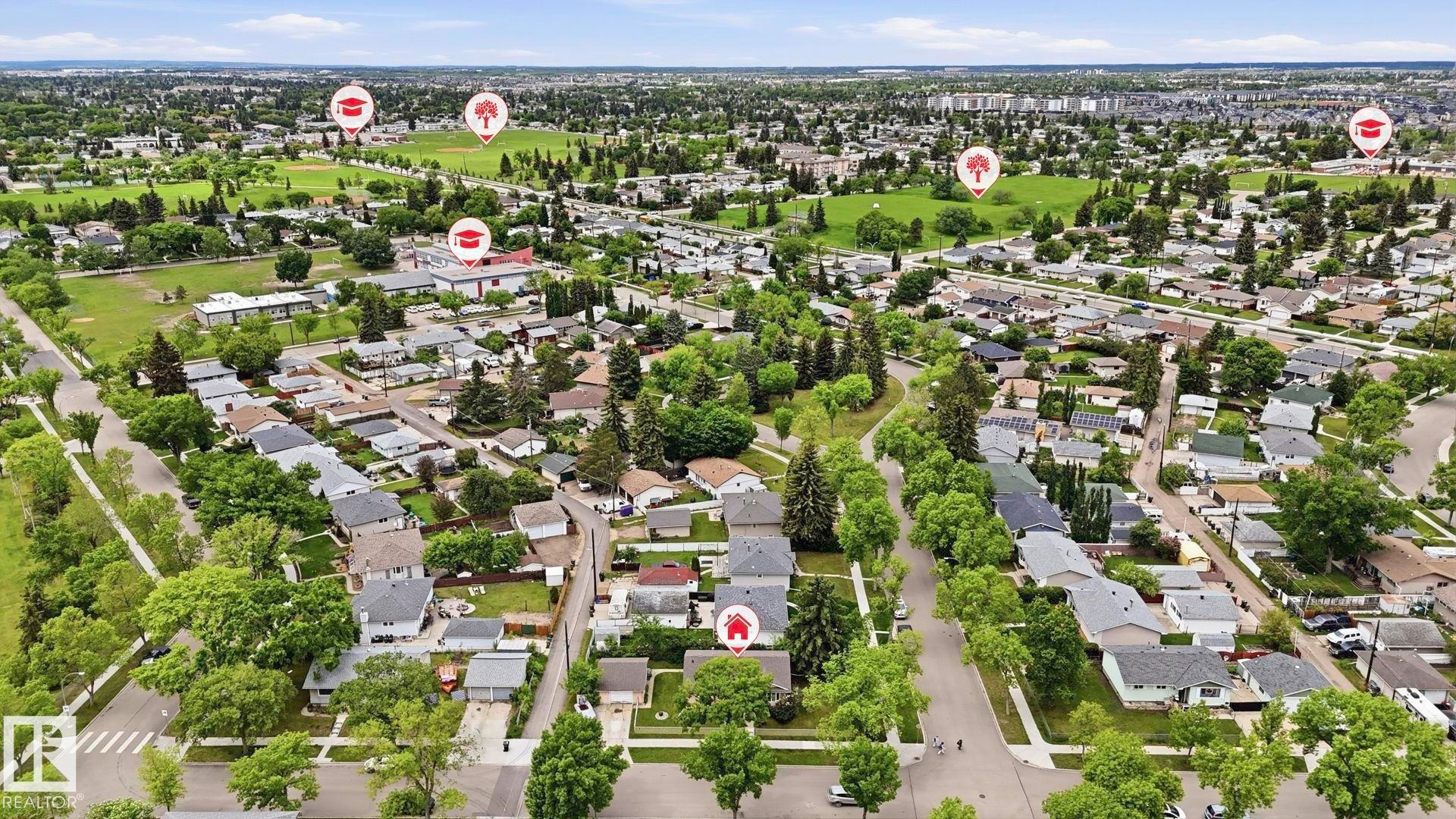 Expansive aerial perspective showcasing a residential neighborhood with numerous detached homes, mature trees, and green spaces - 13008 105 Street Nw, Edmonton, AB - Outdoor With View