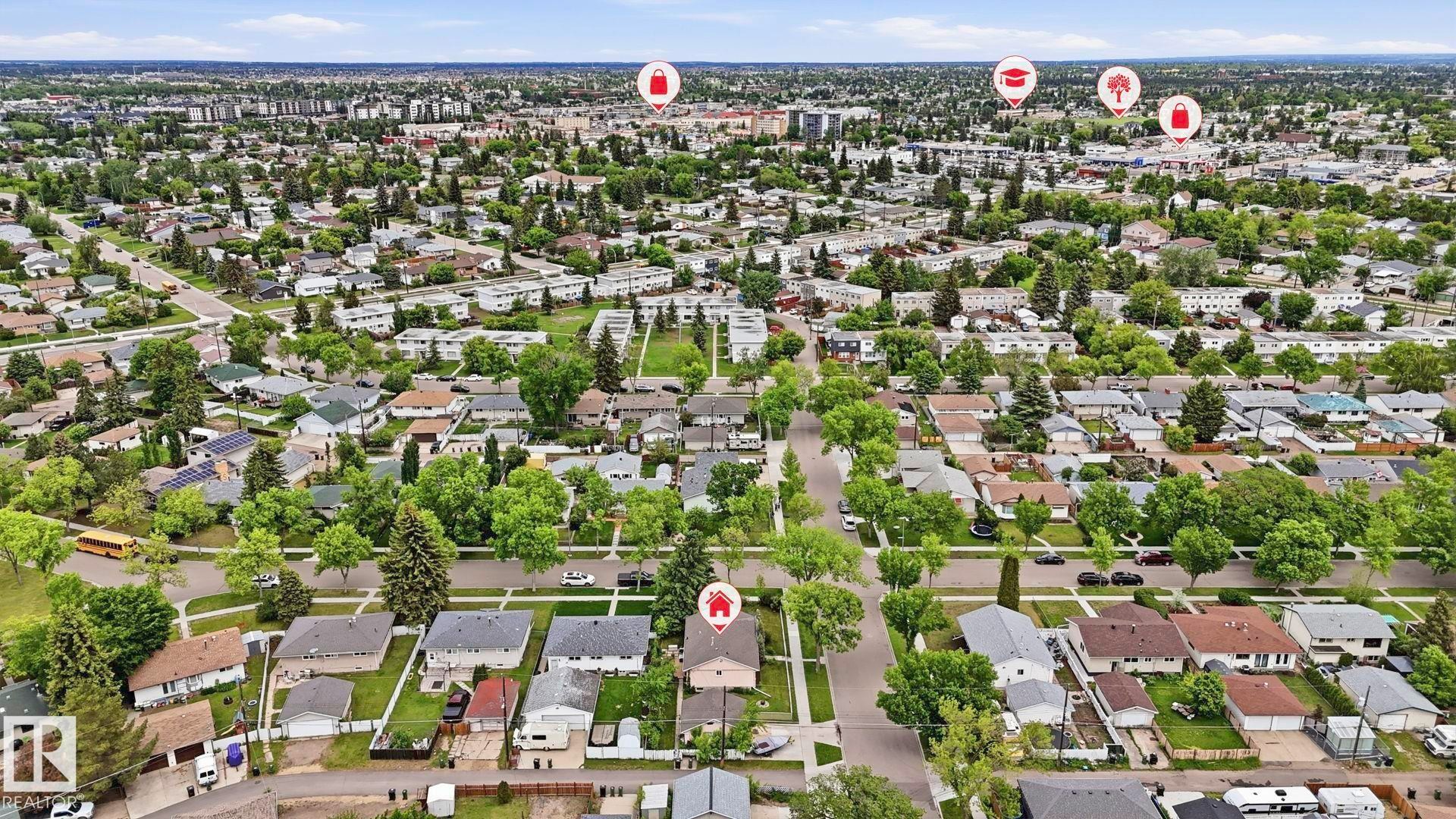 Aerial perspective of a residential neighborhood featuring numerous detached homes with mature trees and paved streets - 13008 105 Street Nw, Edmonton, AB - Outdoor With View