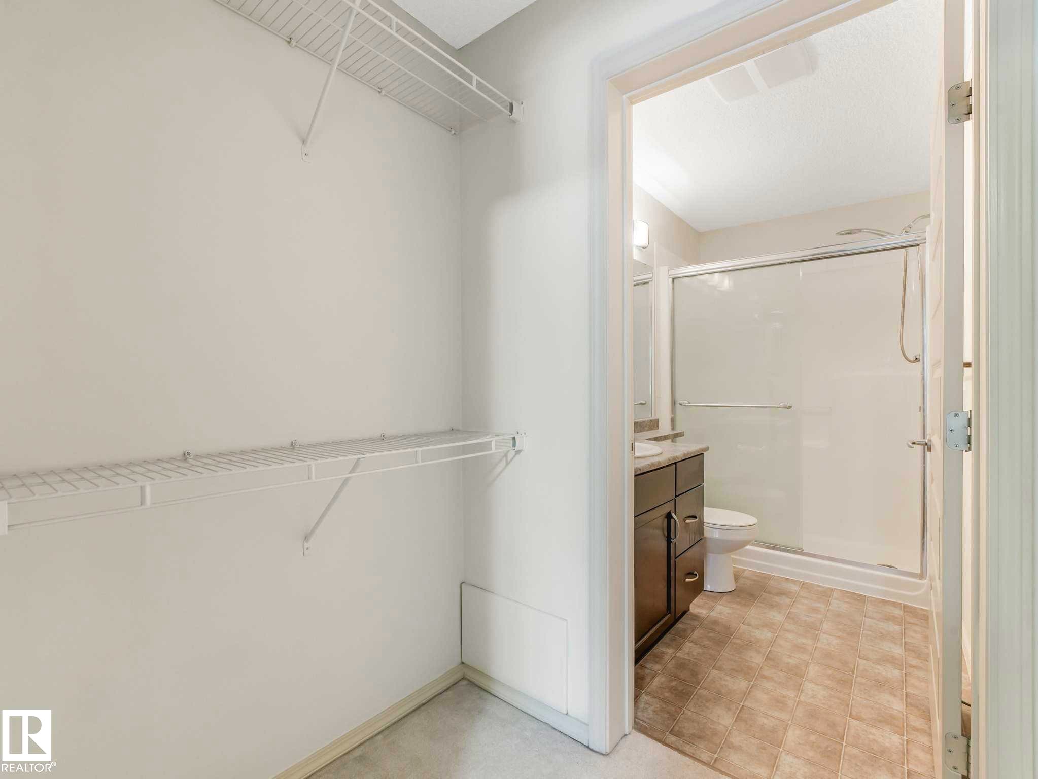 Walk-in closet with white wire shelving - 117 6070 Schonsee Way, Edmonton, AB
