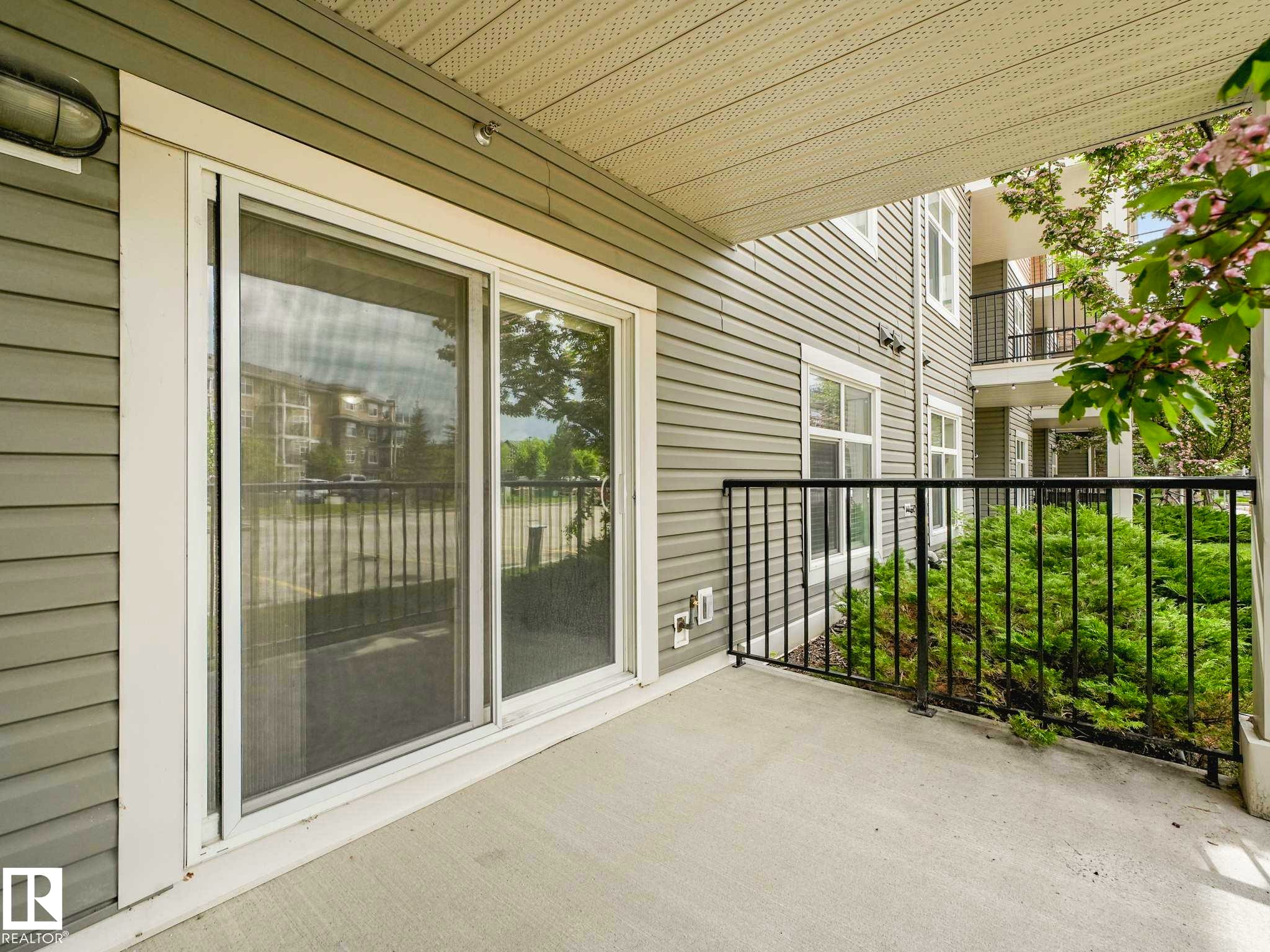 Private balcony featuring a concrete floor, black metal railing, and horizontal siding exterior - 117 6070 Schonsee Way, Edmonton, AB