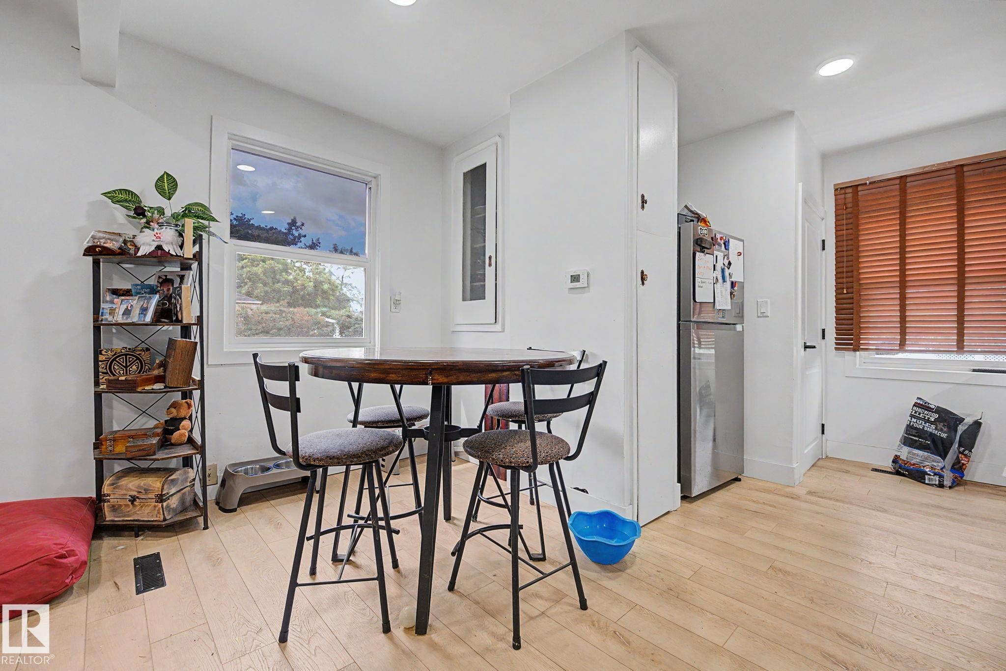 Bright room featuring light wood-finish flooring, recessed ceiling lighting, and a white framed window - 11914 124 Street, Edmonton, AB