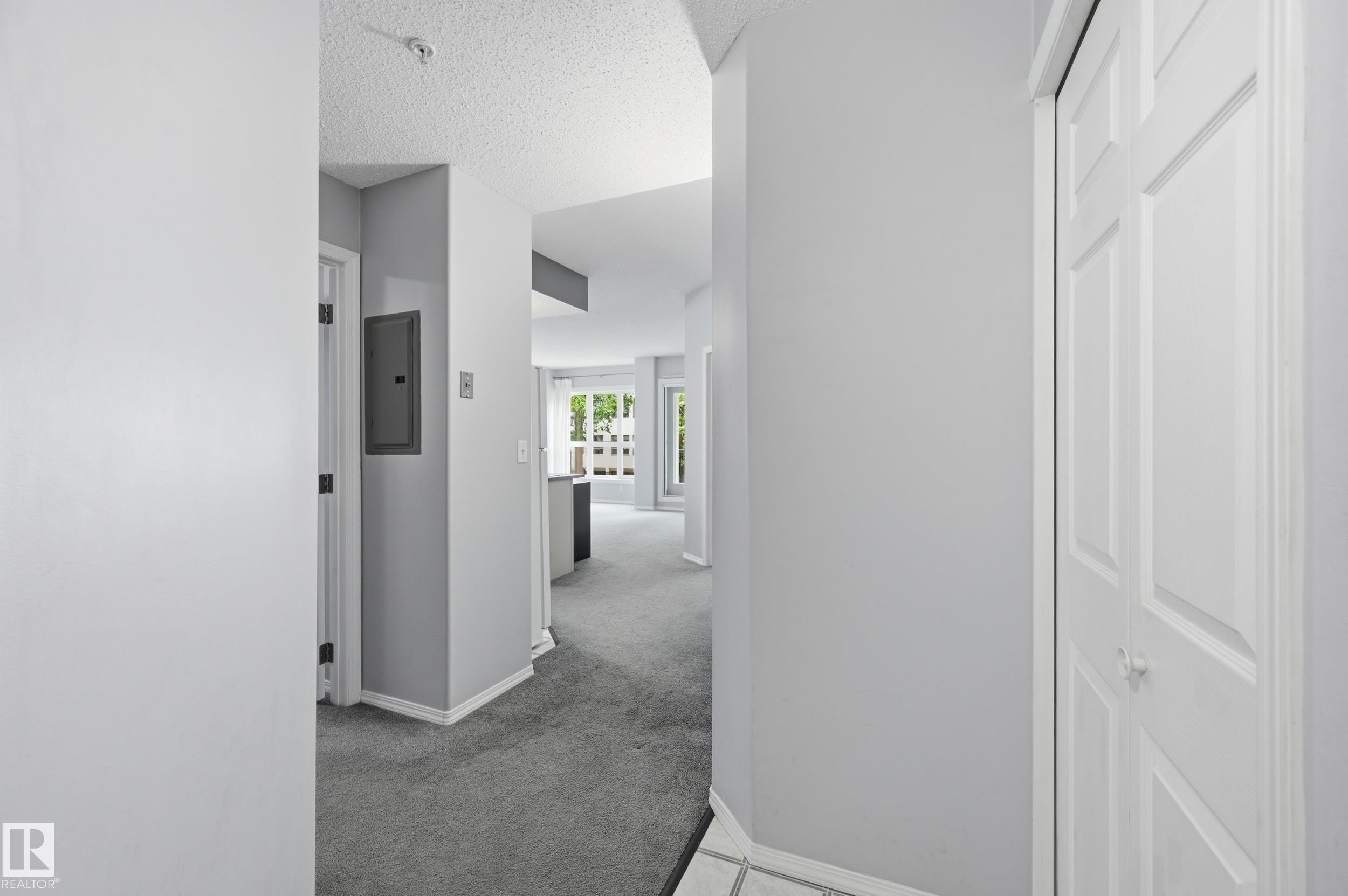 Entryway featuring light gray walls, white trim, and a textured ceiling - 203 11103 84 Avenue, Edmonton, AB