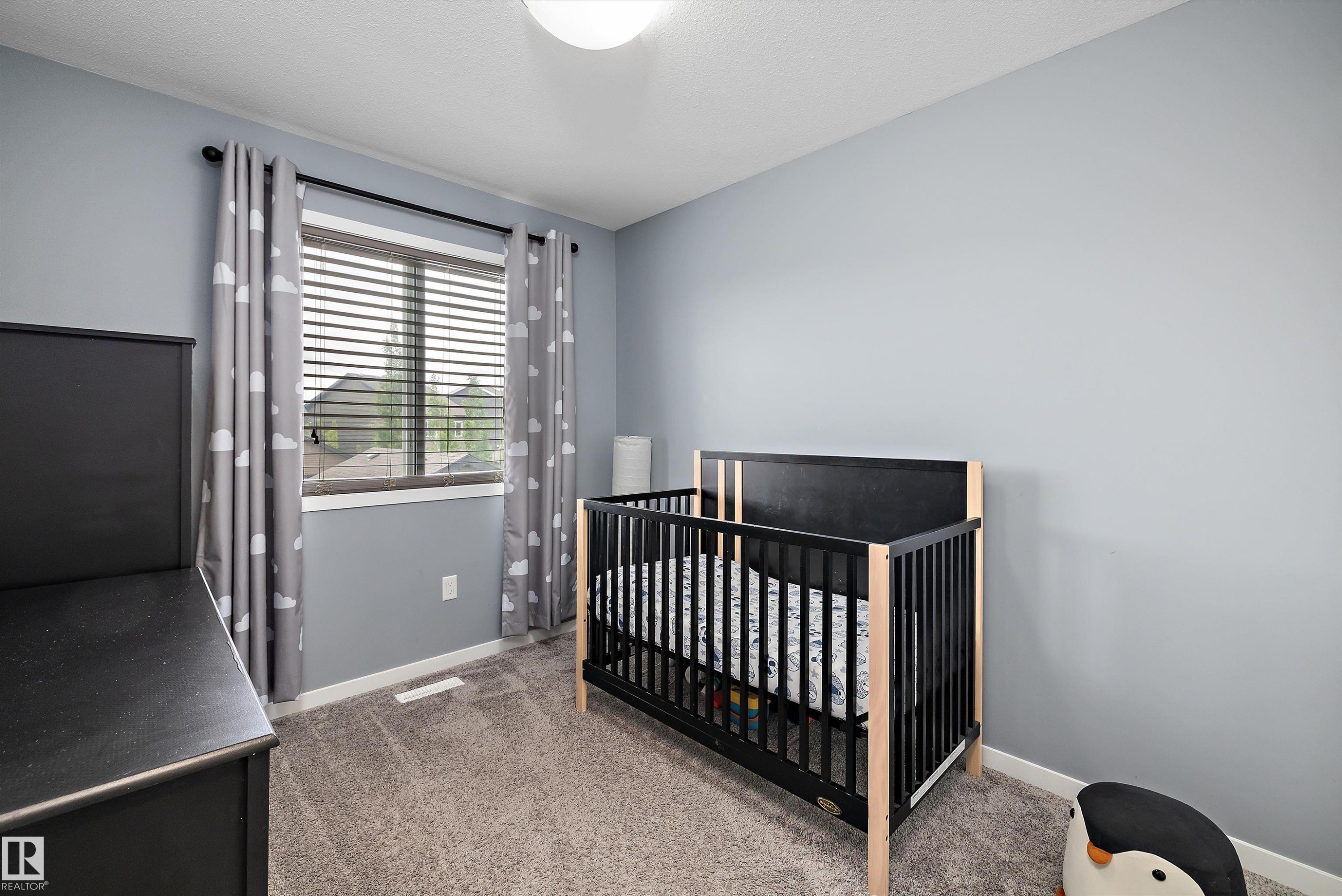 Bedroom featuring neutral-toned carpet flooring, light blue wall paint, and a window with horizontal blinds - 2833 Chokecherry Place, Edmonton, AB