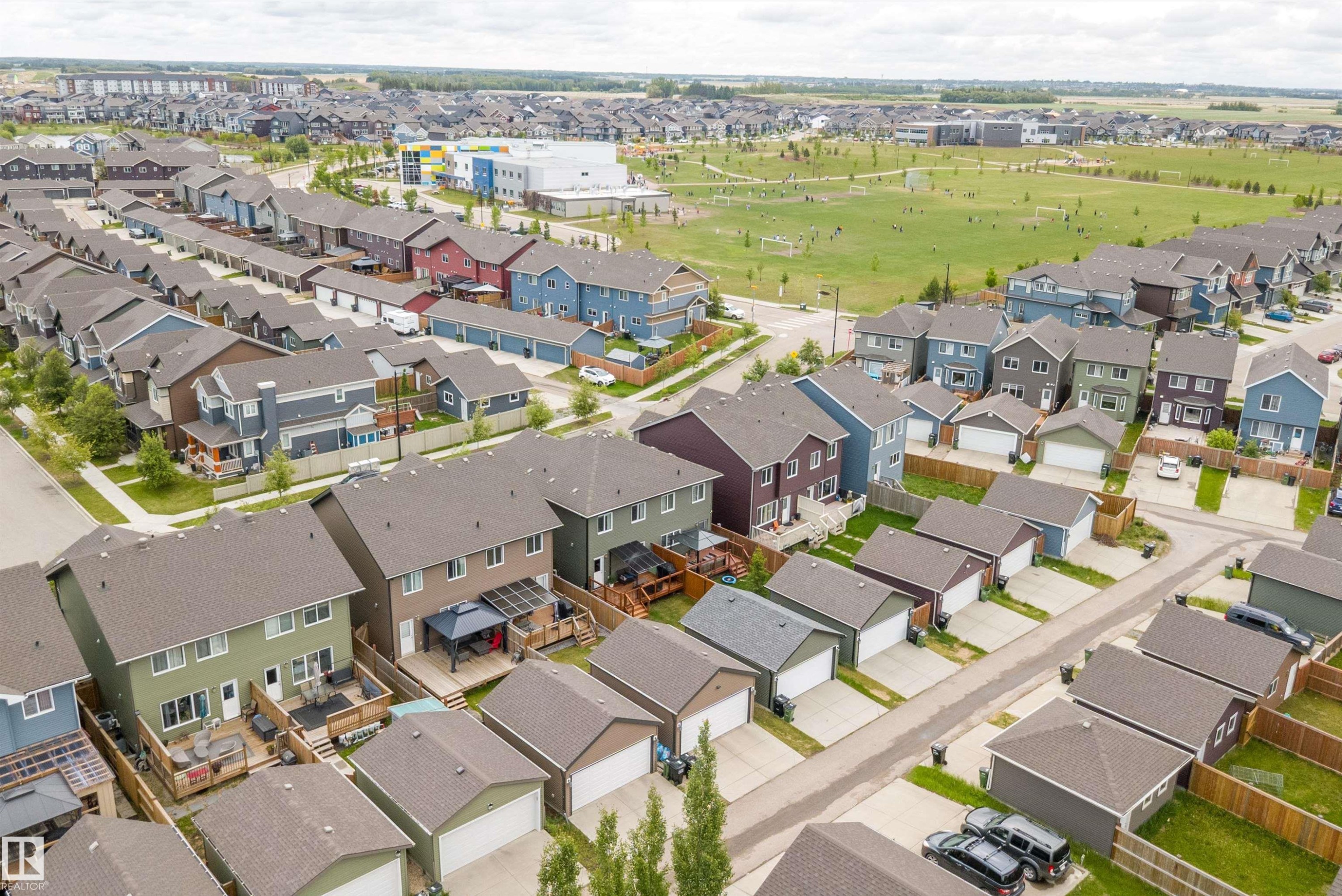 Residential streetscape featuring a variety of detached homes with attached garages, individual fenced yards, and paved driveways - 2833 Chokecherry Place, Edmonton, AB