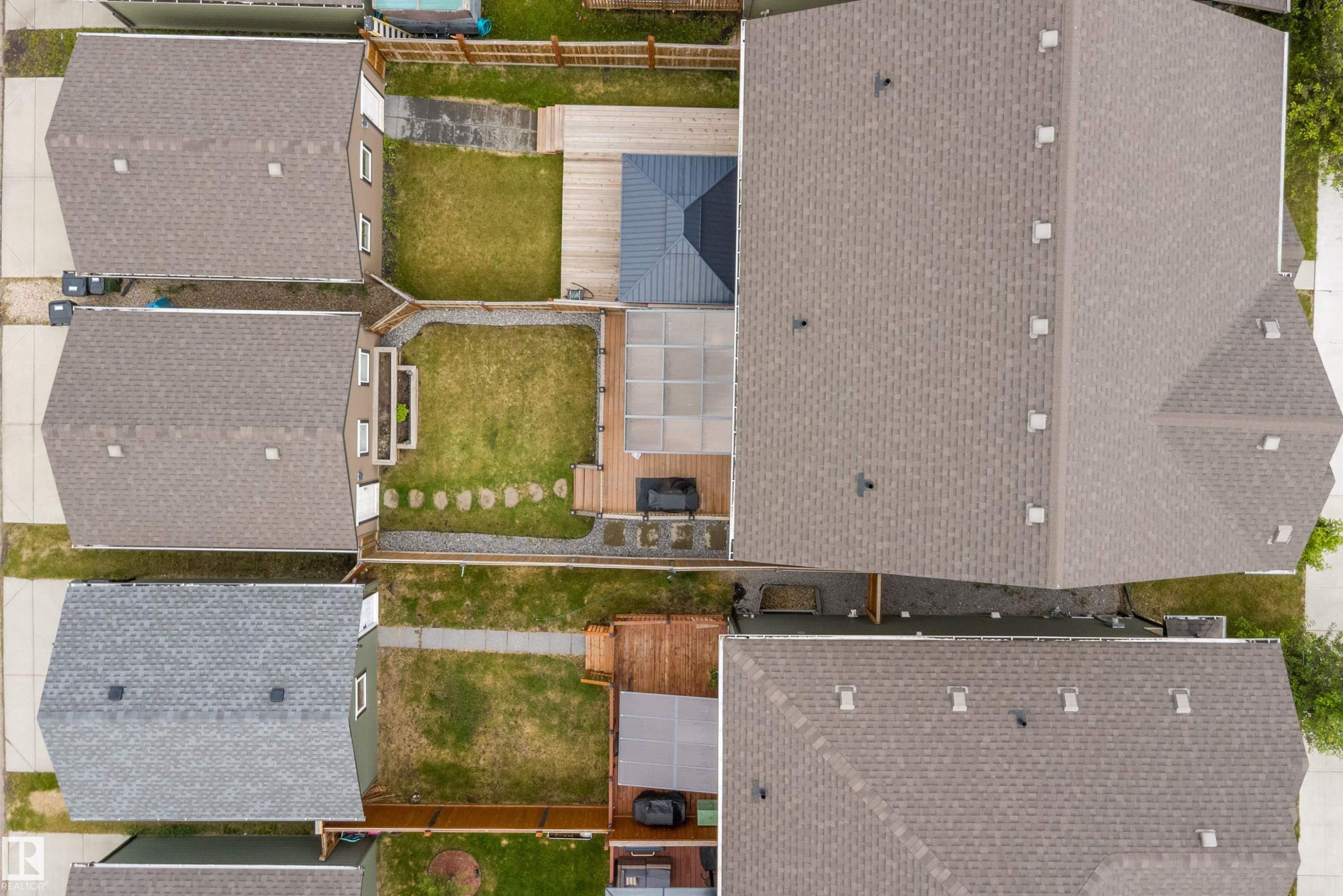 Property features a private backyard with a manicured lawn, a stone pathway, and a multi-level deck for outdoor living - 2833 Chokecherry Place, Edmonton, AB