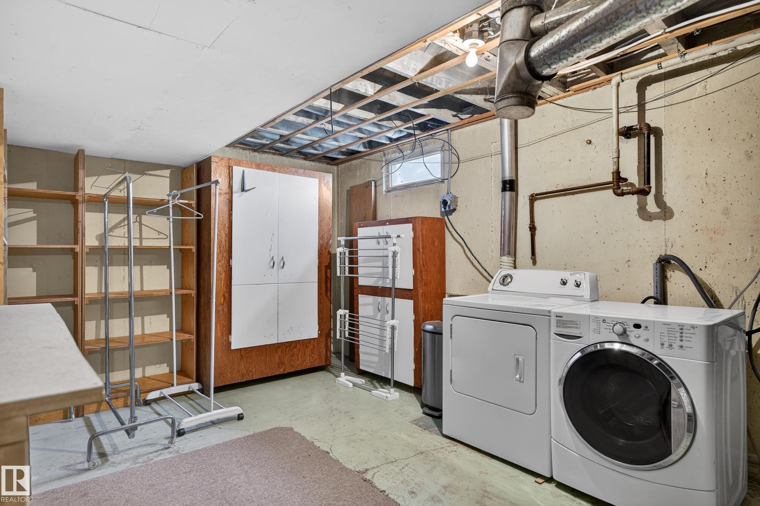 Laundry area with concrete flooring and exposed ceiling joists - 13427 114 Street Nw, Edmonton, AB