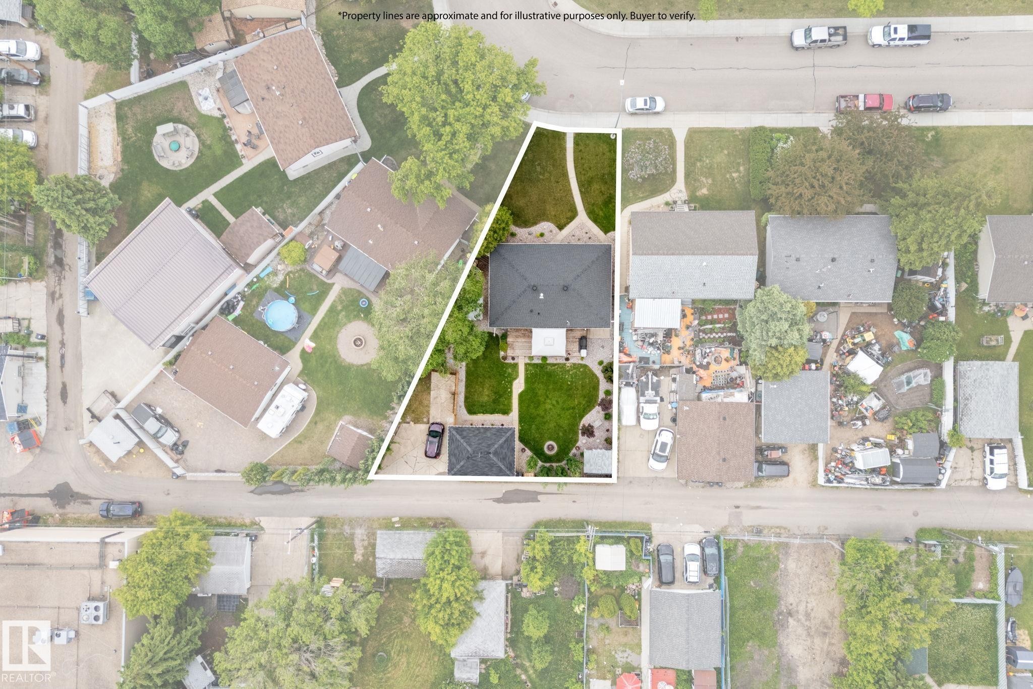Aerial perspective highlighting a residential property with a dark shingle roof and a spacious, manicured lawn - 11219 134A Avenue, Edmonton, AB