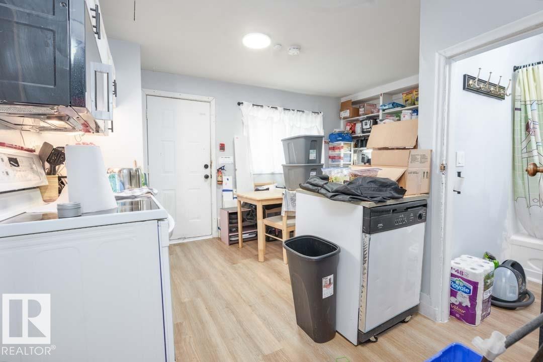 Wood-finish flooring throughout, with a white exterior door and a light-colored wall paint - 11308 94 Street, Edmonton, AB