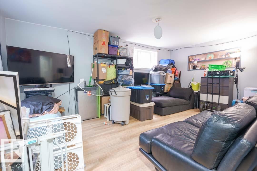 Room featuring wood-finish flooring, light grey wall paint, and a white ceiling with a single flush-mount light fixture - 11308 94 Street, Edmonton, AB