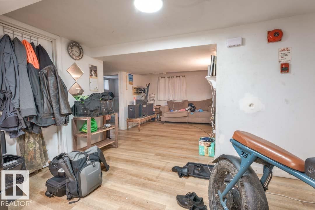 Wood-finish flooring throughout, featuring a recessed ceiling light and white painted walls - 11308 94 Street, Edmonton, AB