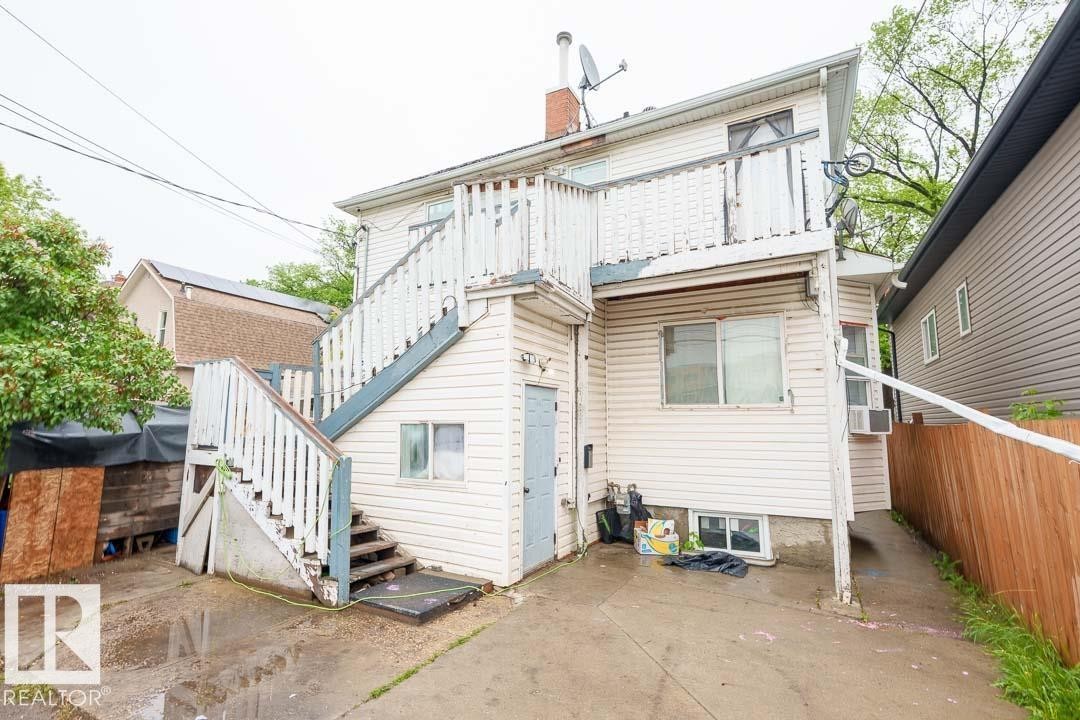 Rear exterior with two levels of siding, an upper-level balcony, and an external staircase - 11308 94 Street, Edmonton, AB
