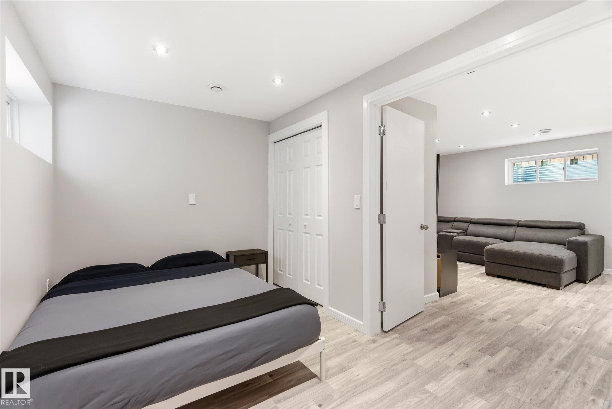 Light-filled bedroom featuring wood-finish flooring, recessed lighting, and a bi-fold closet - 3685 Westcliff Way, Edmonton, AB