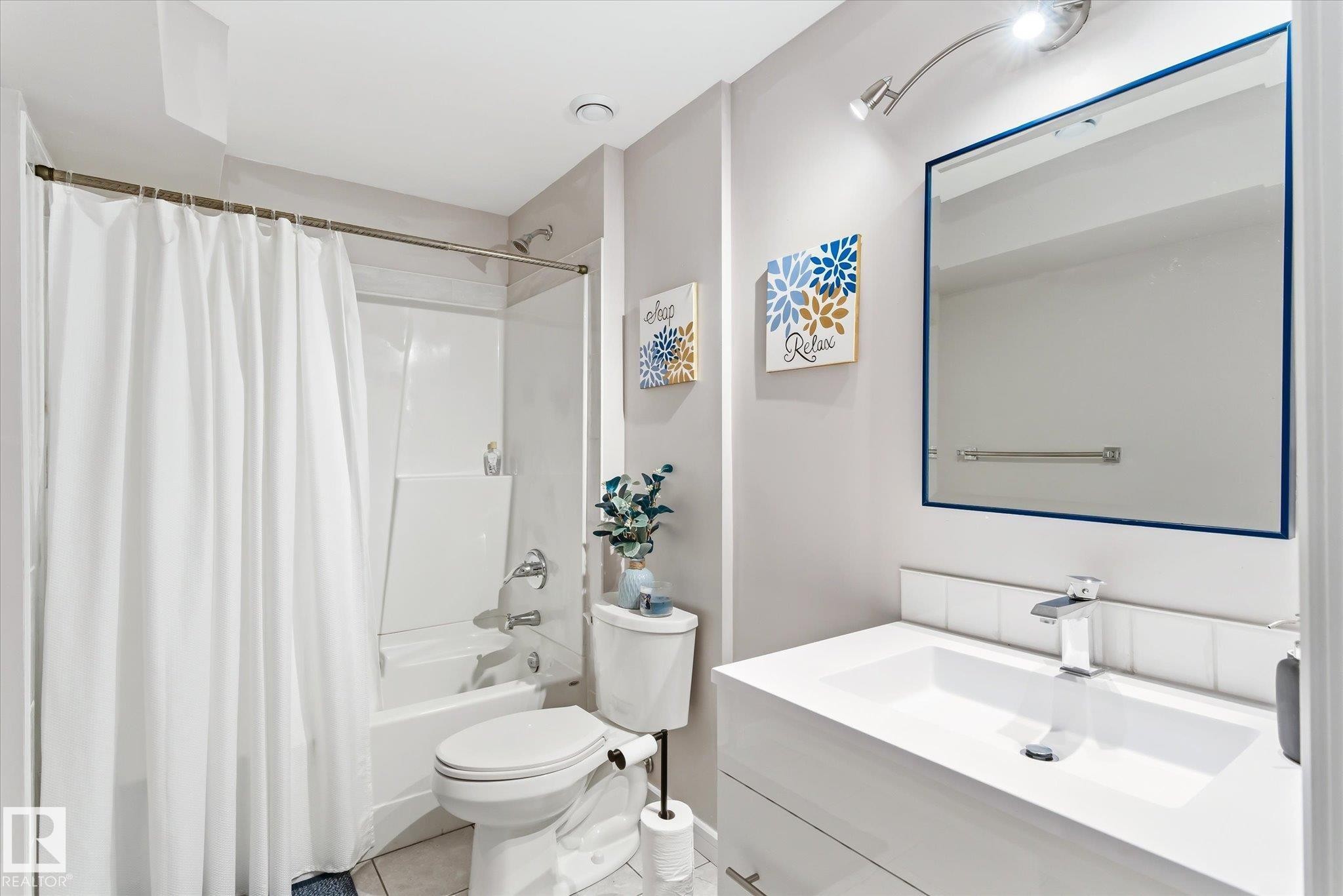 Full bathroom featuring a white vanity with integrated sink, chrome faucet, and rectangular mirror - 3685 Westcliff Way, Edmonton, AB