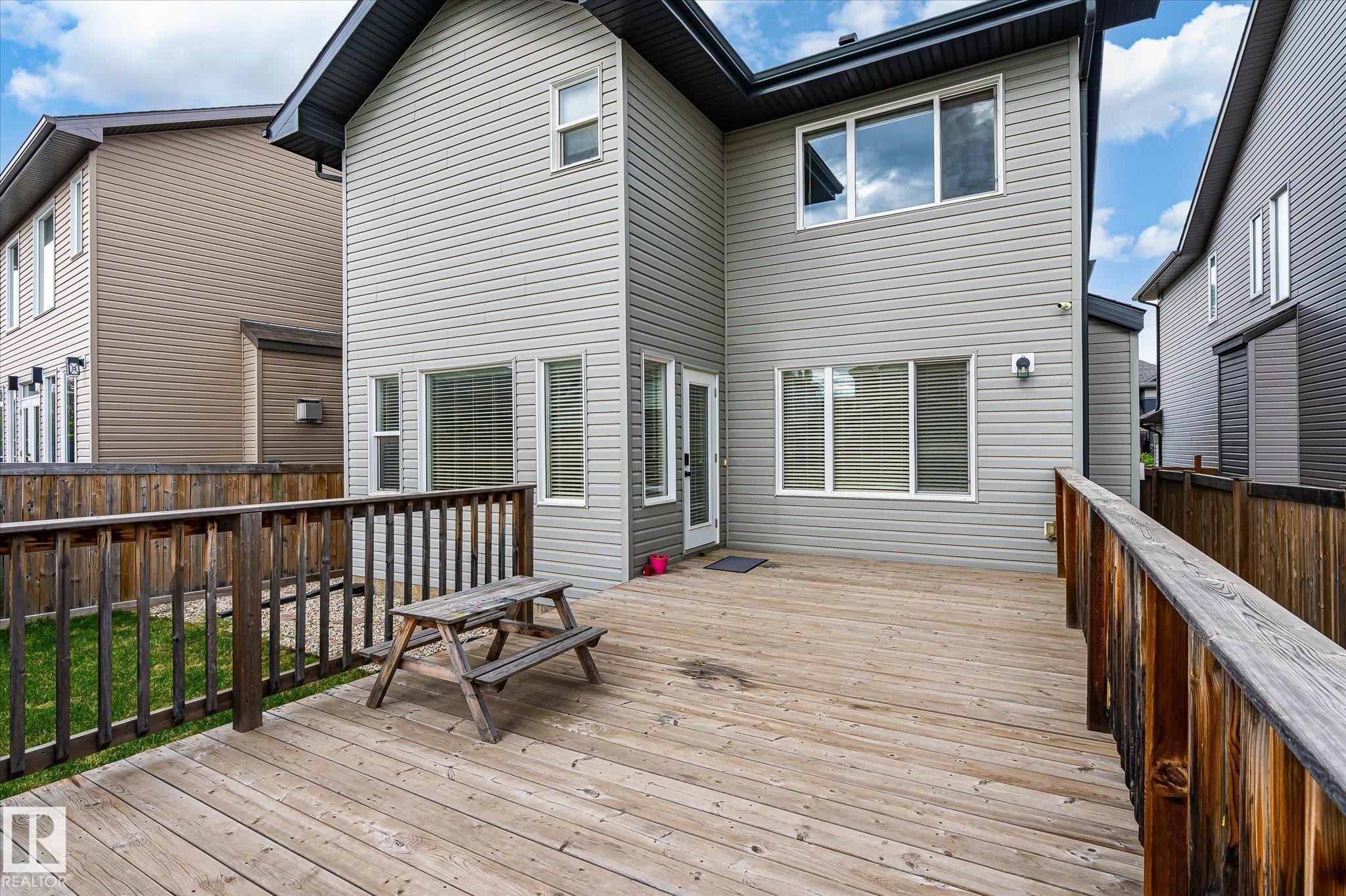 Spacious rear deck featuring wood-finish flooring and a full wood-slat railing - 3685 Westcliff Way, Edmonton, AB