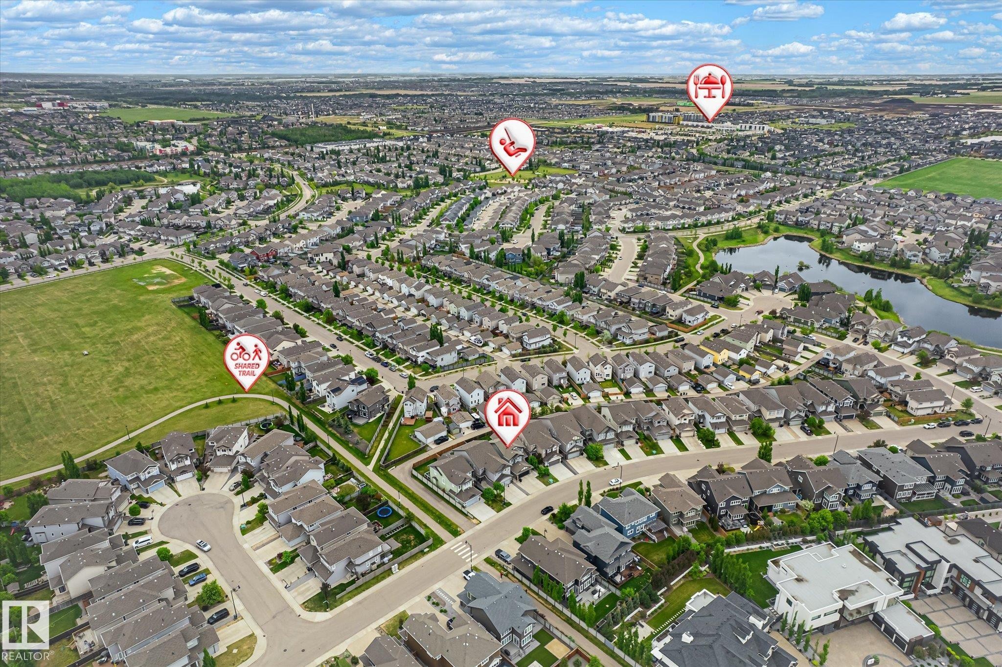 Expansive residential community featuring numerous single-family homes, green spaces, and a prominent pond - 3685 Westcliff Way, Edmonton, AB