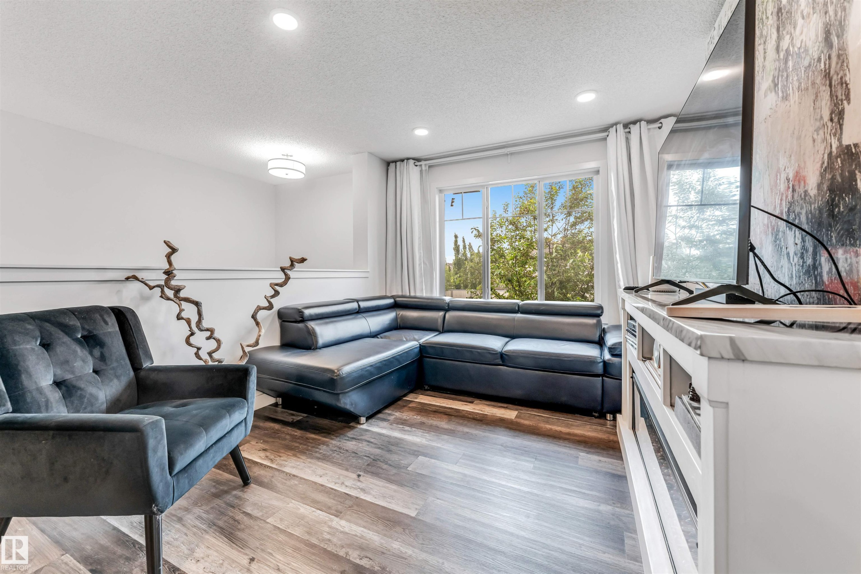 Living space featuring wood-finish flooring and white baseboards - 116 3305 Orchards Link Sw, Edmonton, AB