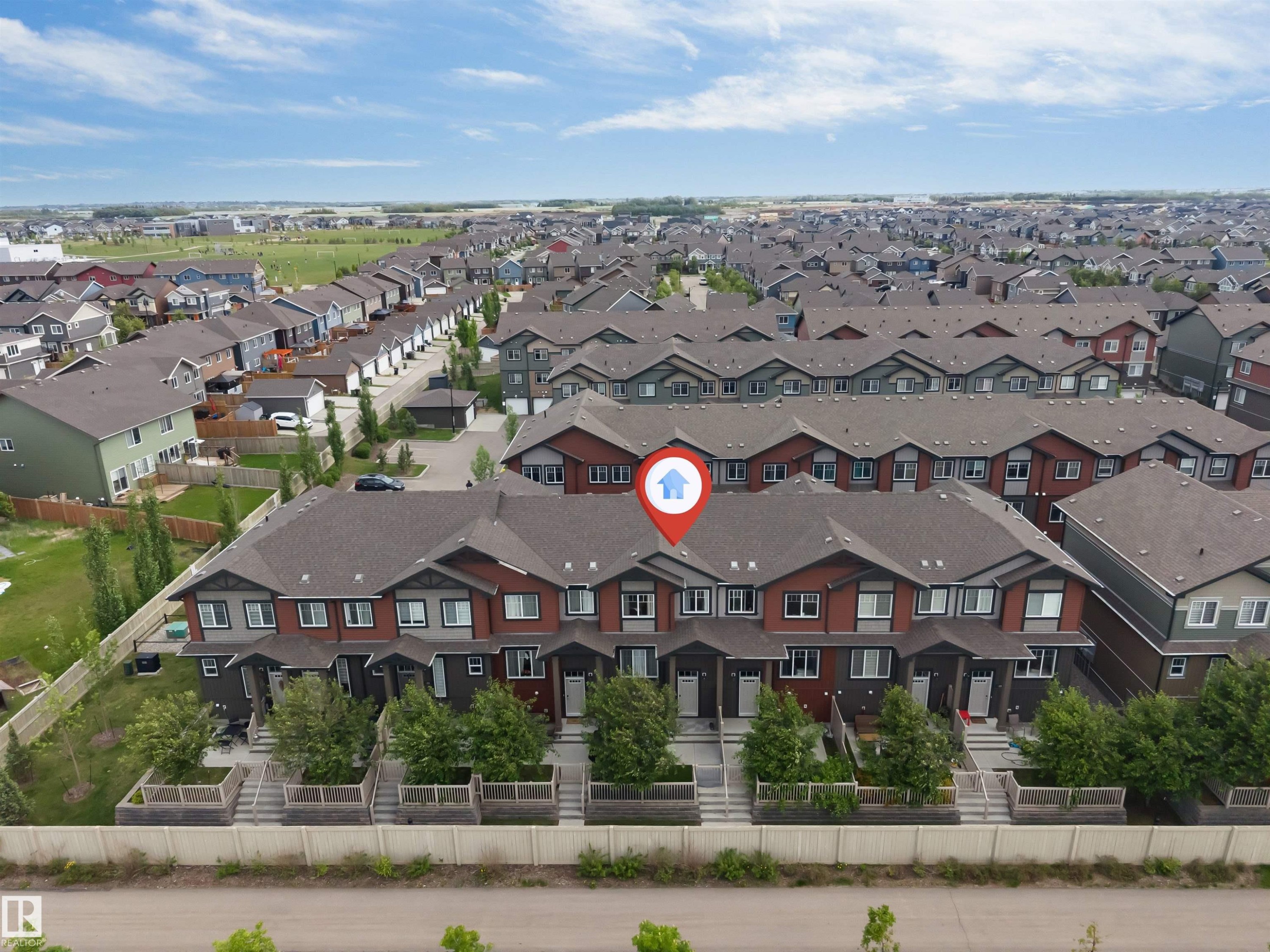 Townhouse community featuring diverse architectural styles, individual front entrances, and mature landscaping - 116 3305 Orchards Link Sw, Edmonton, AB