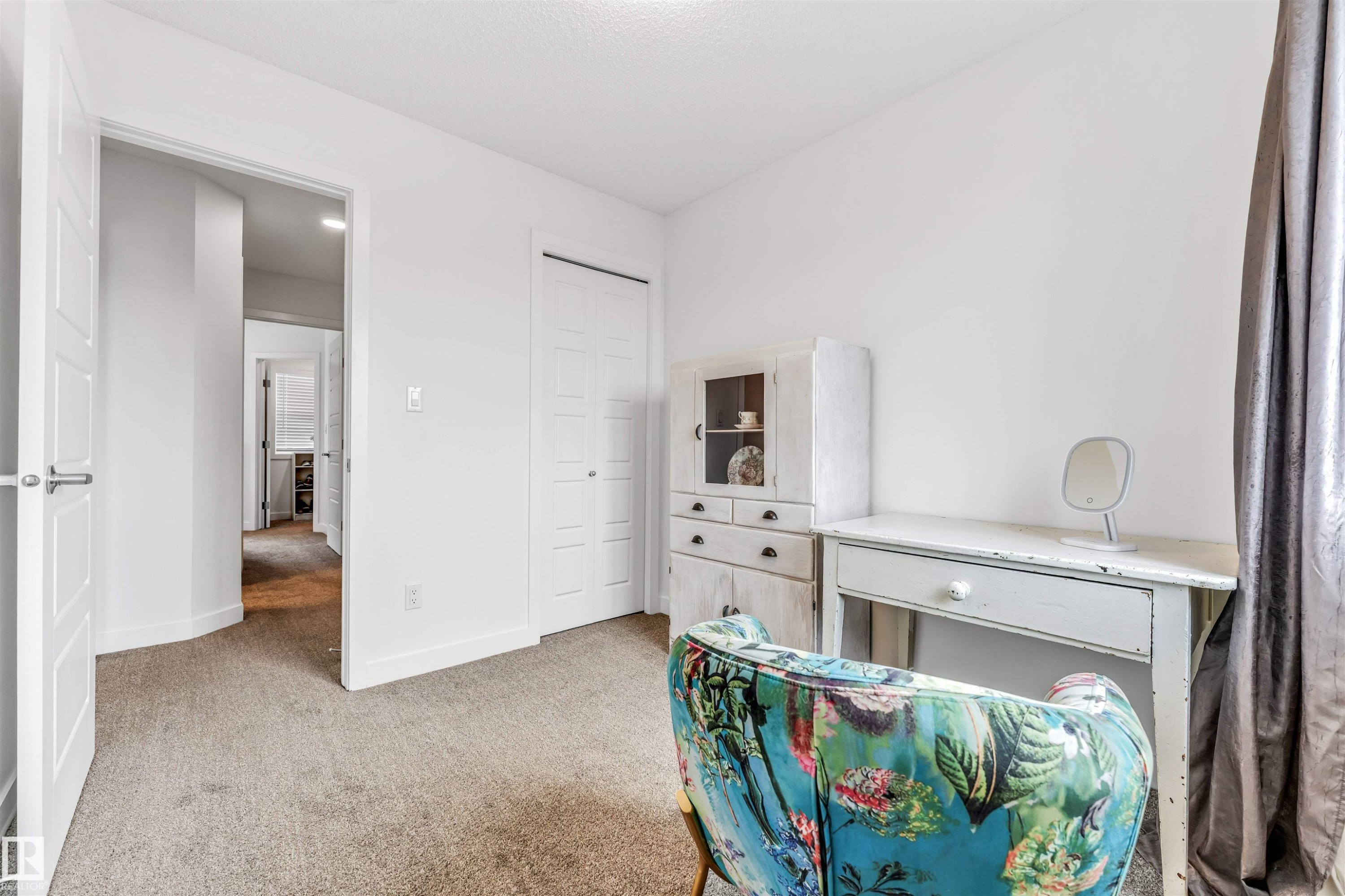 Carpeted room with white walls, a white paneled door, and a white bi-fold closet door - 116 3305 Orchards Link Sw, Edmonton, AB