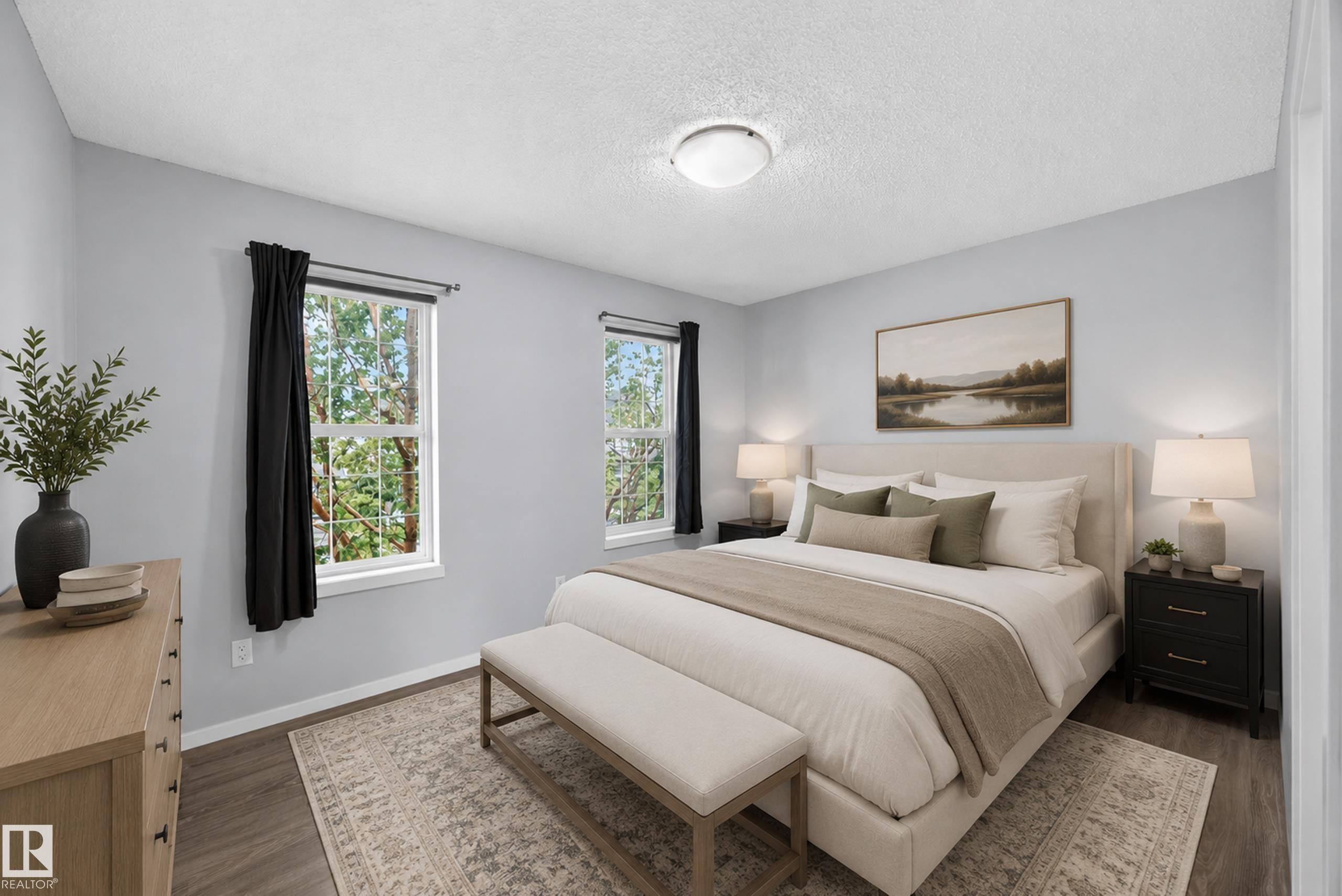 Spacious room featuring wood-finish flooring, light grey walls, and two large windows with white trim - 3634 12 Street, Edmonton, AB