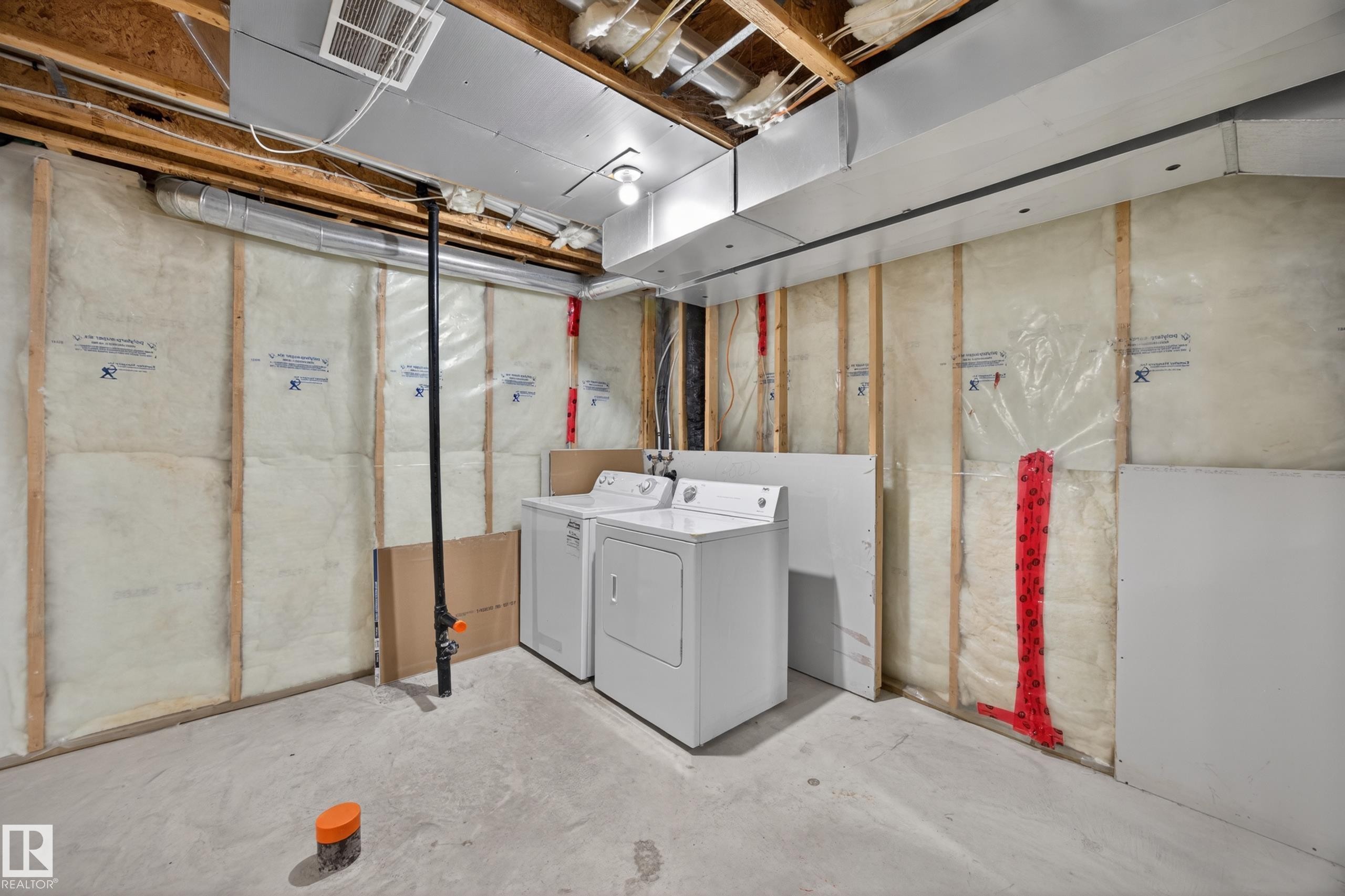 Basement utility area featuring exposed wood joists and subfloor, visible insulation, concrete flooring, and exposed ductwork - 3634 12 Street, Edmonton, AB