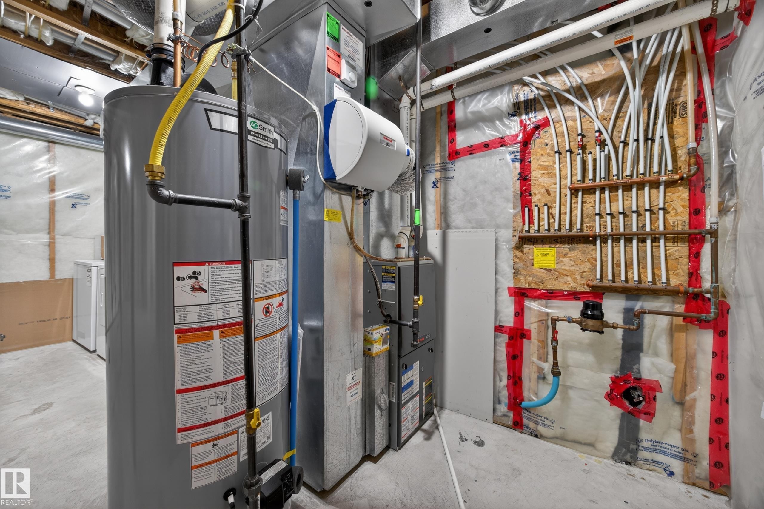 Utility space featuring a water heater, furnace, and comprehensive plumbing manifold system - 3634 12 Street, Edmonton, AB
