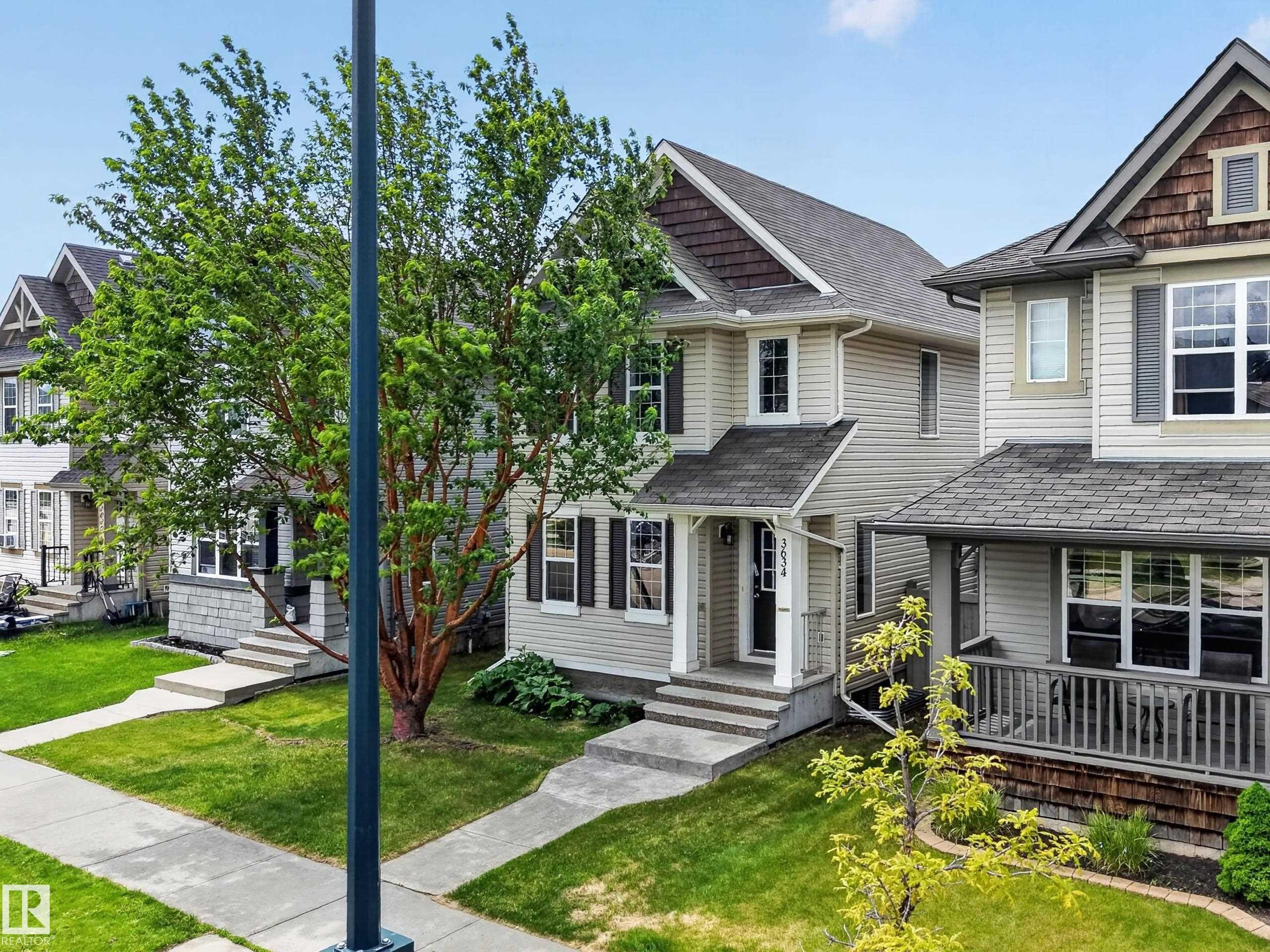 Three-story residence featuring light-colored siding and a dark roofline - 3634 12 Street, Edmonton, AB