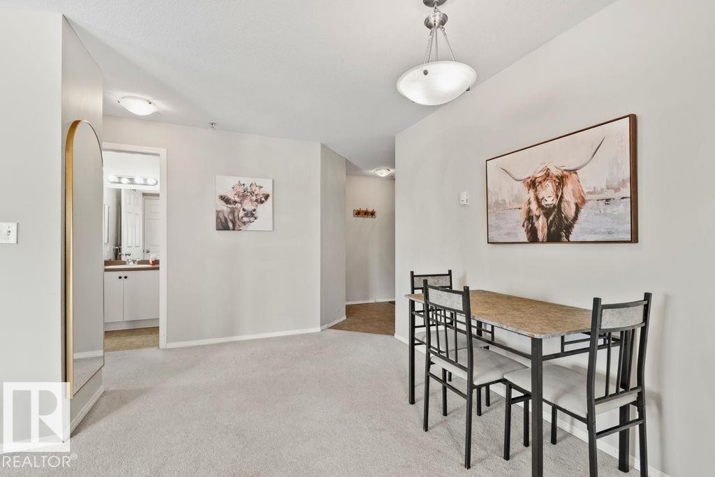 Open-concept room featuring light gray carpeting, white baseboards, and a semi-flush ceiling light fixture - 232 4309 33 Street, Stony Plain, AB