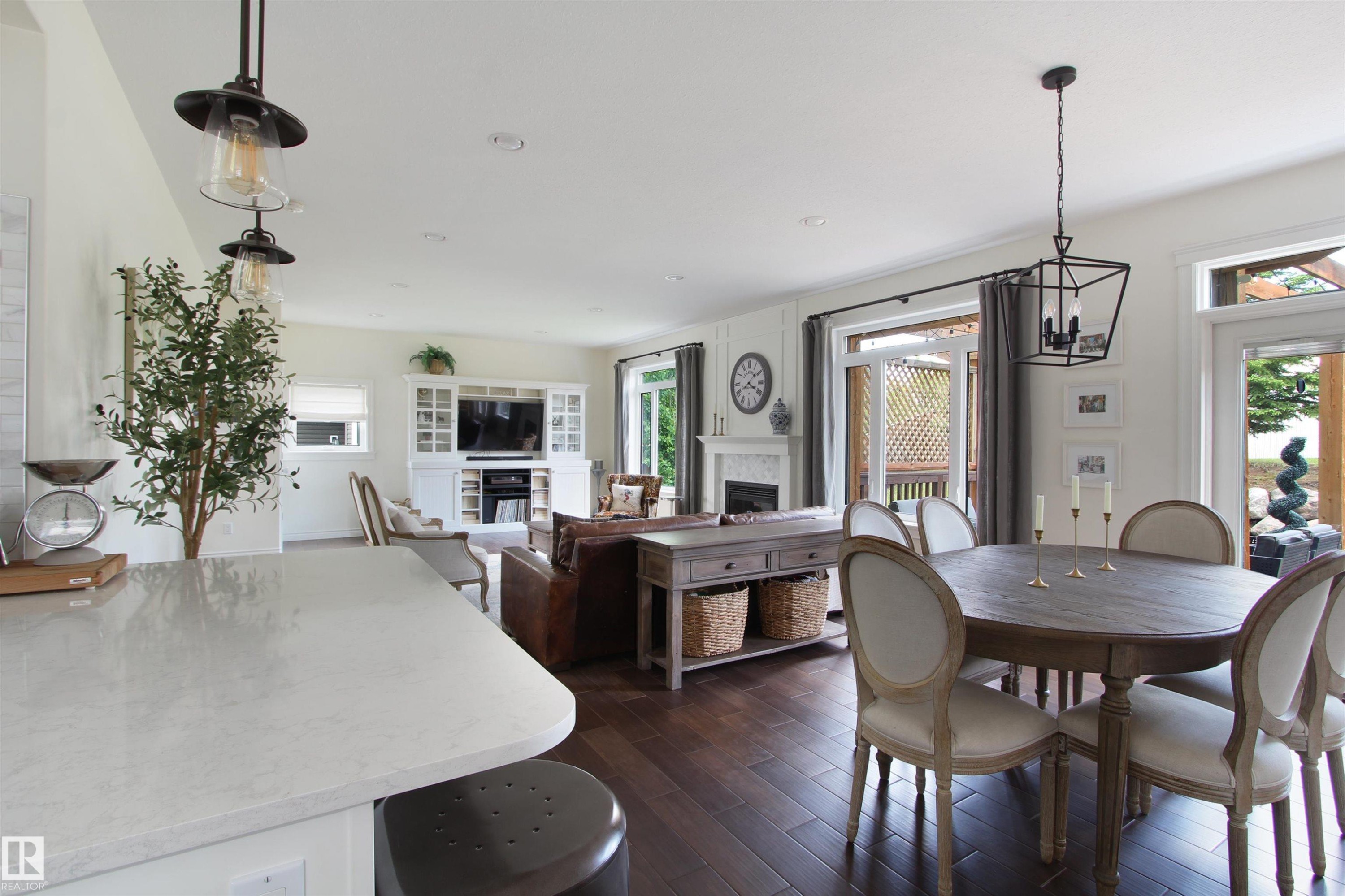 Open-concept living space featuring wood-finish flooring, a white-mantel fireplace, recessed lighting, and a white built-in media center - 34 Falcon Road, Cold Lake, AB