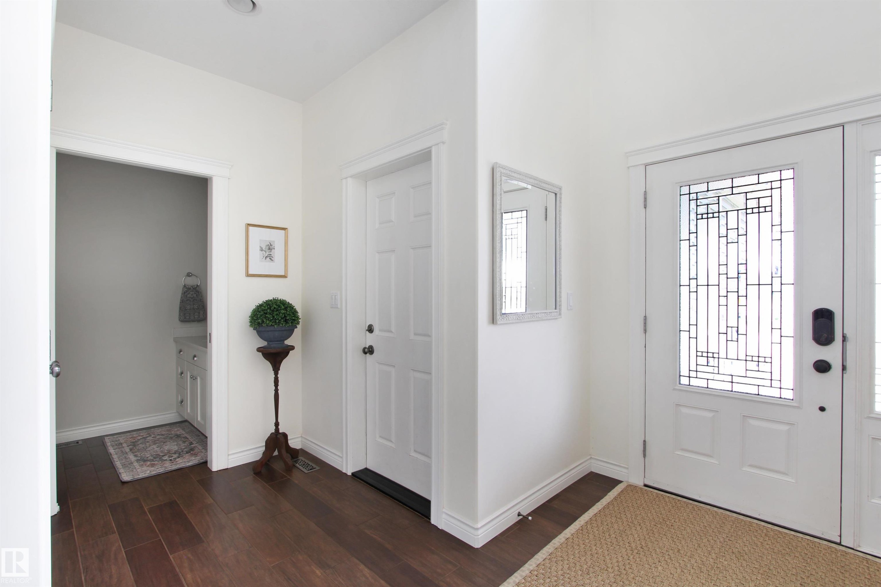 Front entry featuring a decorative glass panel door and wood-finish flooring - 34 Falcon Road, Cold Lake, AB