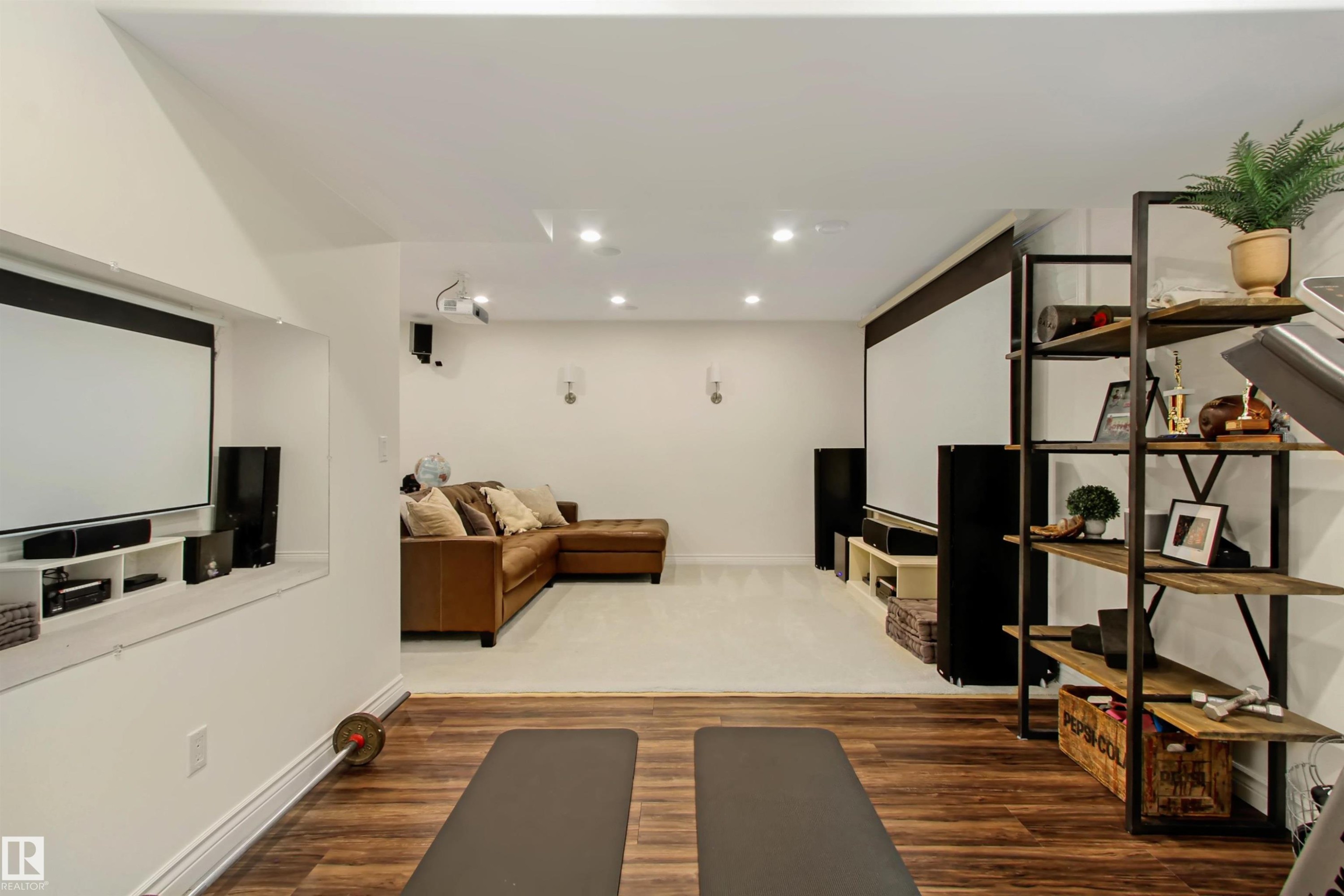 Recreation room featuring wood-finish flooring, recessed lighting, and a built-in projection screen - 34 Falcon Road, Cold Lake, AB