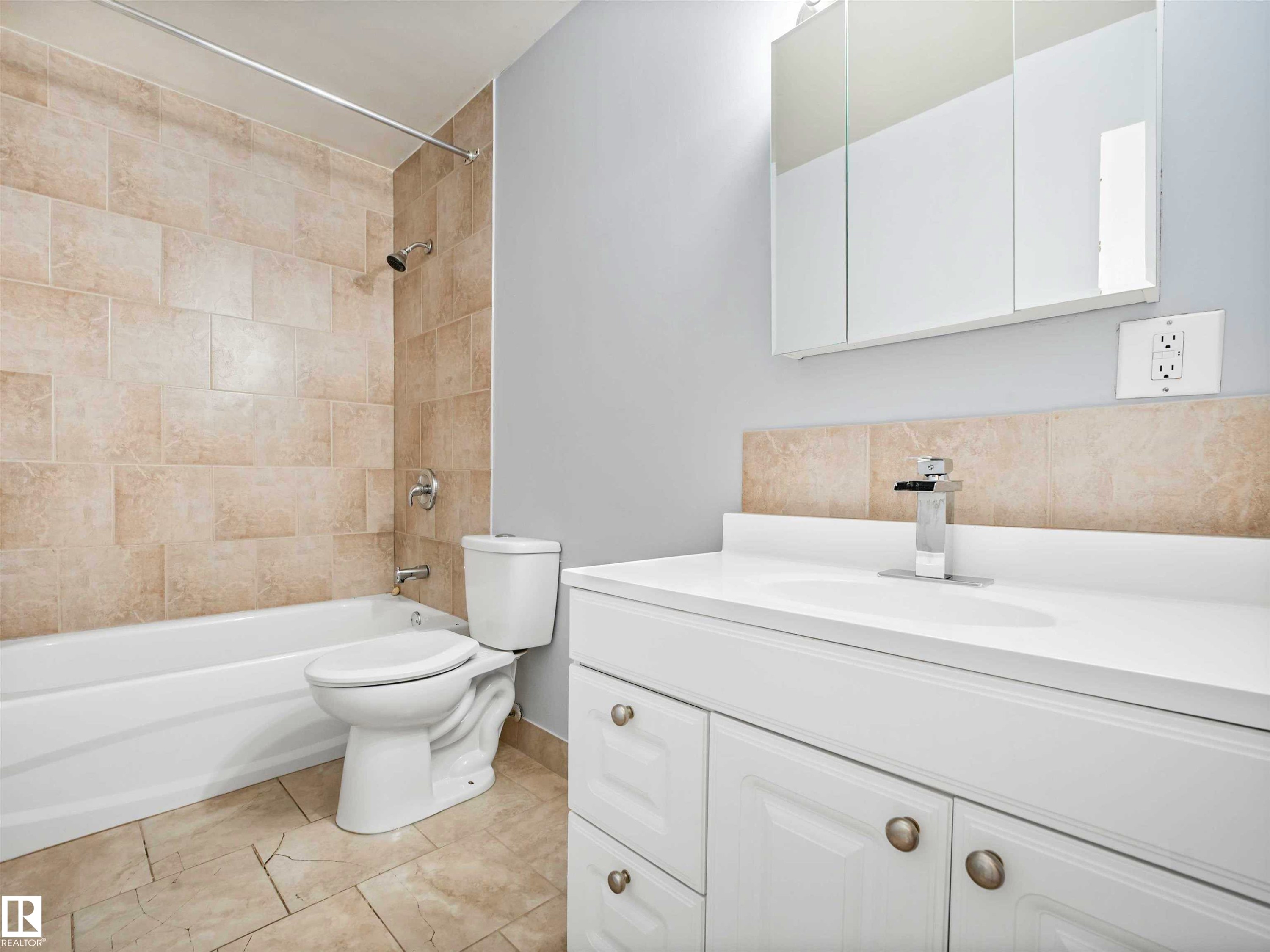 Bathroom featuring a white vanity with integrated sink, chrome faucet, and three-panel mirrored medicine cabinet - 13114 30 Street, Edmonton, AB - Indoor Photo Showing Bathroom