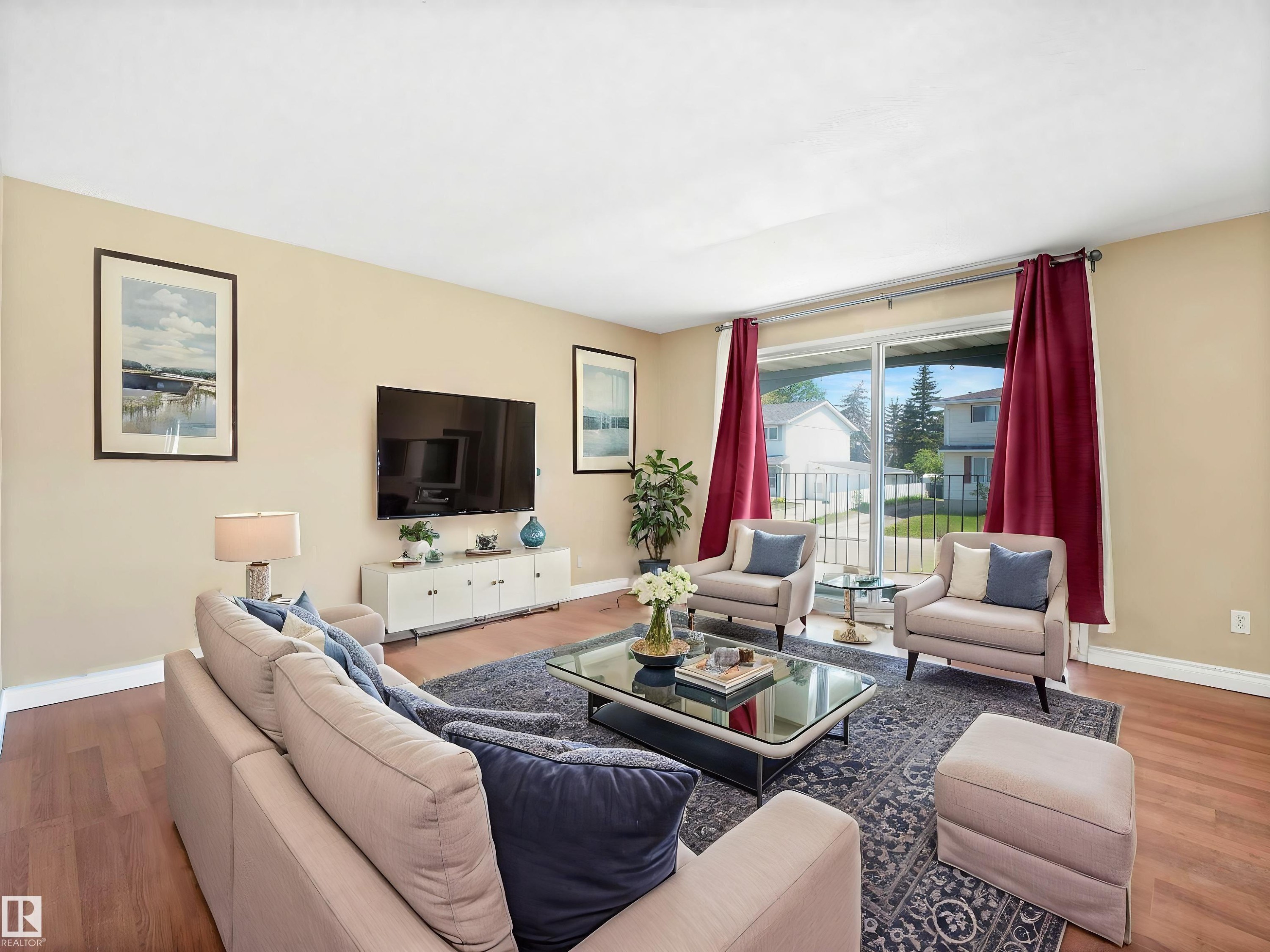 Living area featuring wood-finish flooring, a neutral color palette, and a large sliding glass door - 13114 30 Street, Edmonton, AB - Indoor Photo Showing Living Room
