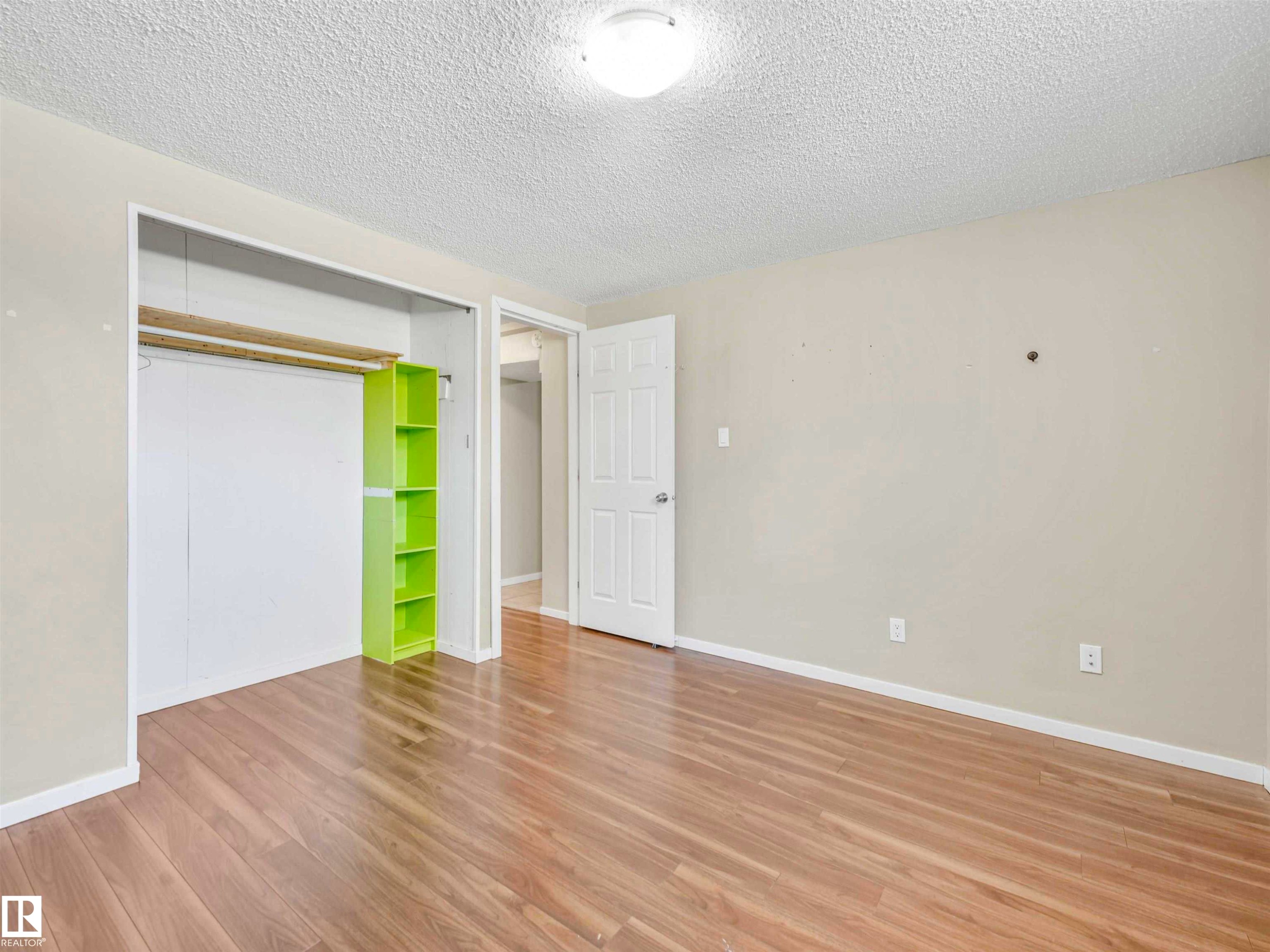 Room featuring wood-finish flooring, light neutral wall paint, and a textured ceiling - 13114 30 Street, Edmonton, AB - Indoor Photo Showing Other Room