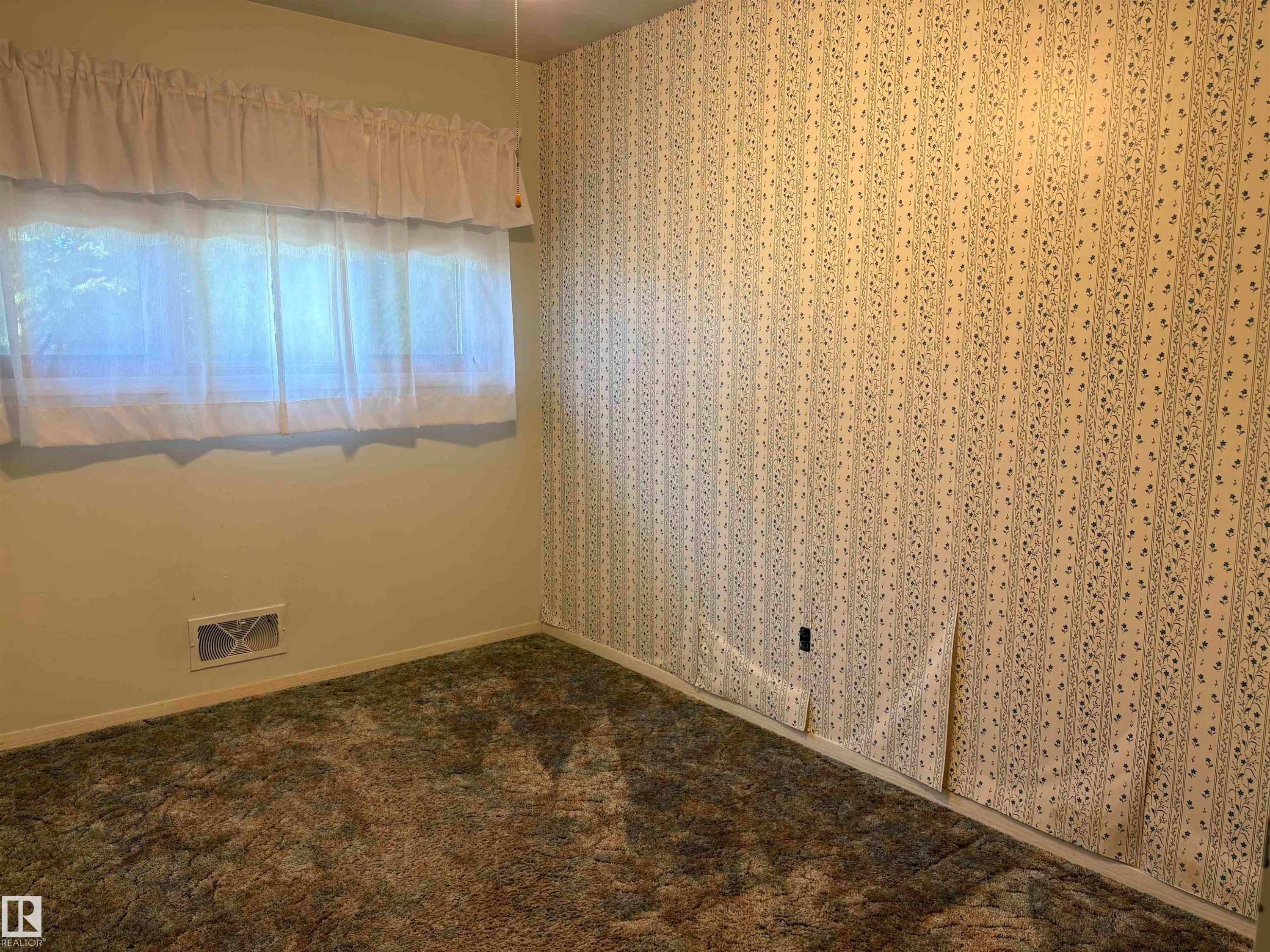Room featuring patterned wallpaper, light green painted wall, light filtering window treatments, and carpet flooring - 5511 50 St, Tofield, AB