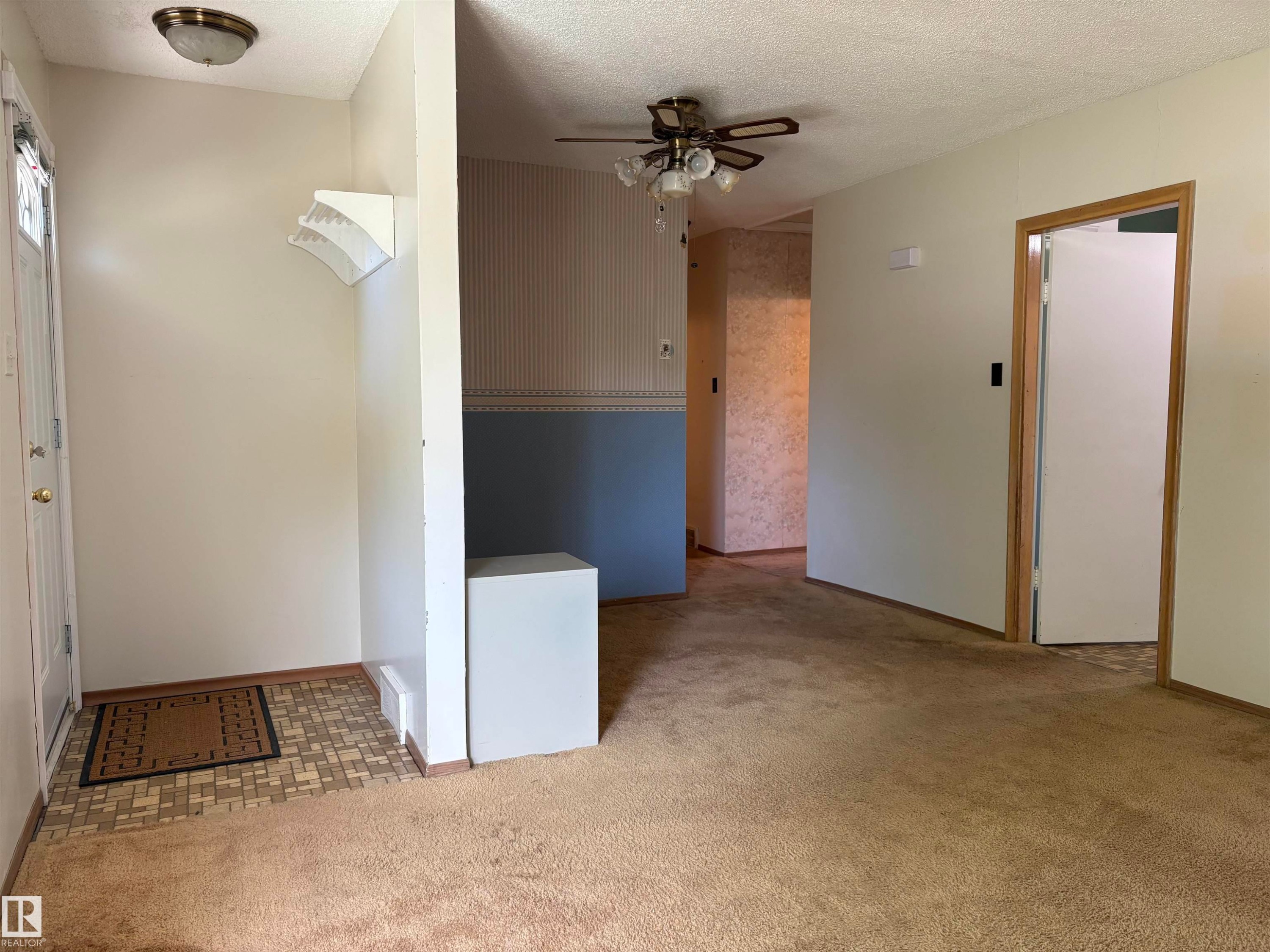 Entryway with patterned tile flooring and a white paneled door - 5511 50 St, Tofield, AB