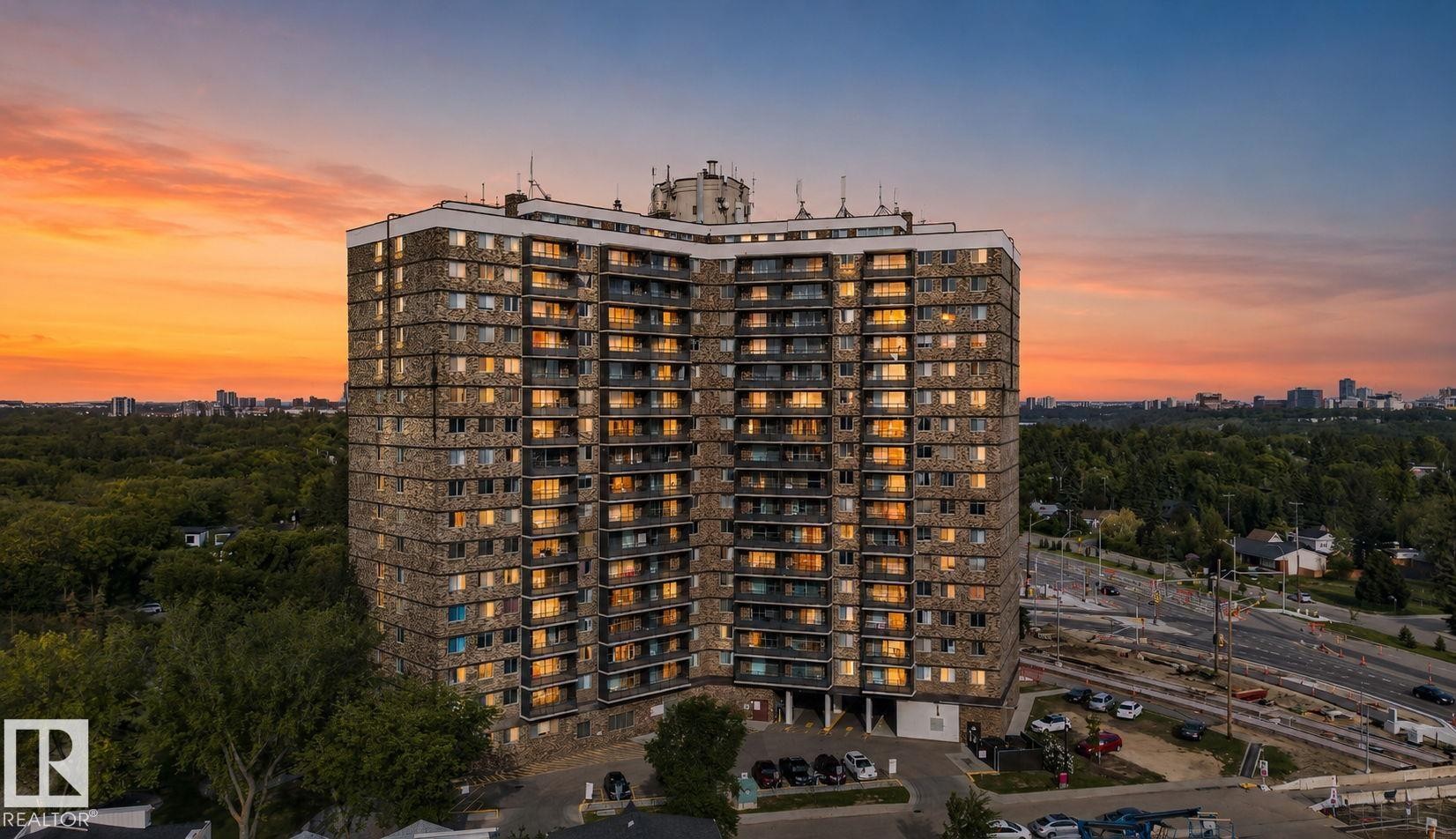 Multi-story building featuring stone-clad facade, numerous balconies, and expansive windows - #412 13910 Stony Plain Rd Nw, Edmonton, AB - Outdoor With View