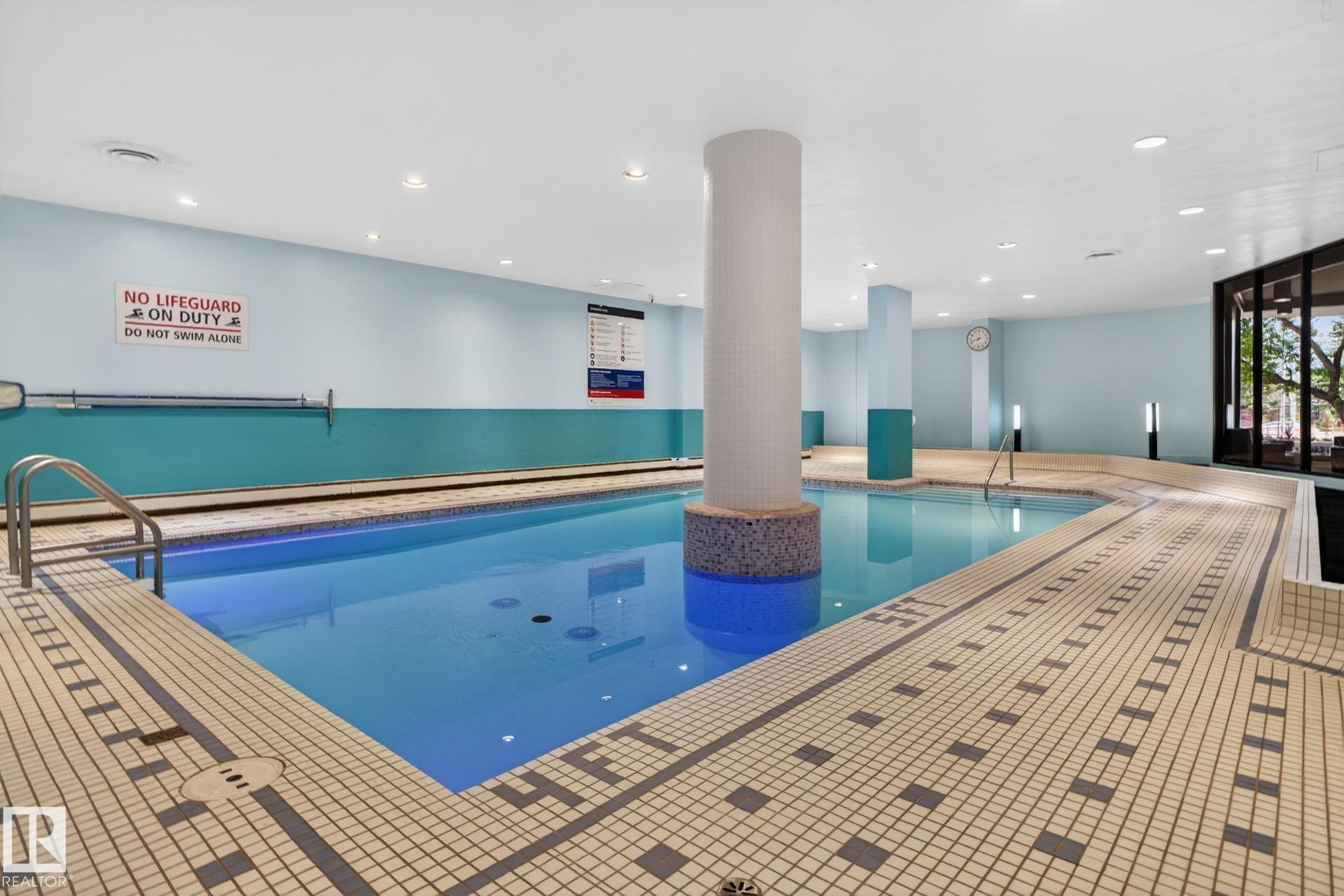Indoor swimming pool featuring light blue walls, recessed lighting, and large windows - #412 13910 Stony Plain Rd Nw, Edmonton, AB - Indoor Photo Showing Other Room