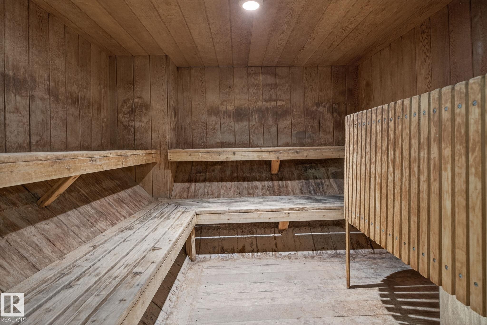 Wood-paneled room featuring tiered wood benches, a slatted wood partition, and a recessed ceiling light - #412 13910 Stony Plain Rd Nw, Edmonton, AB - Indoor Photo Showing Other Room