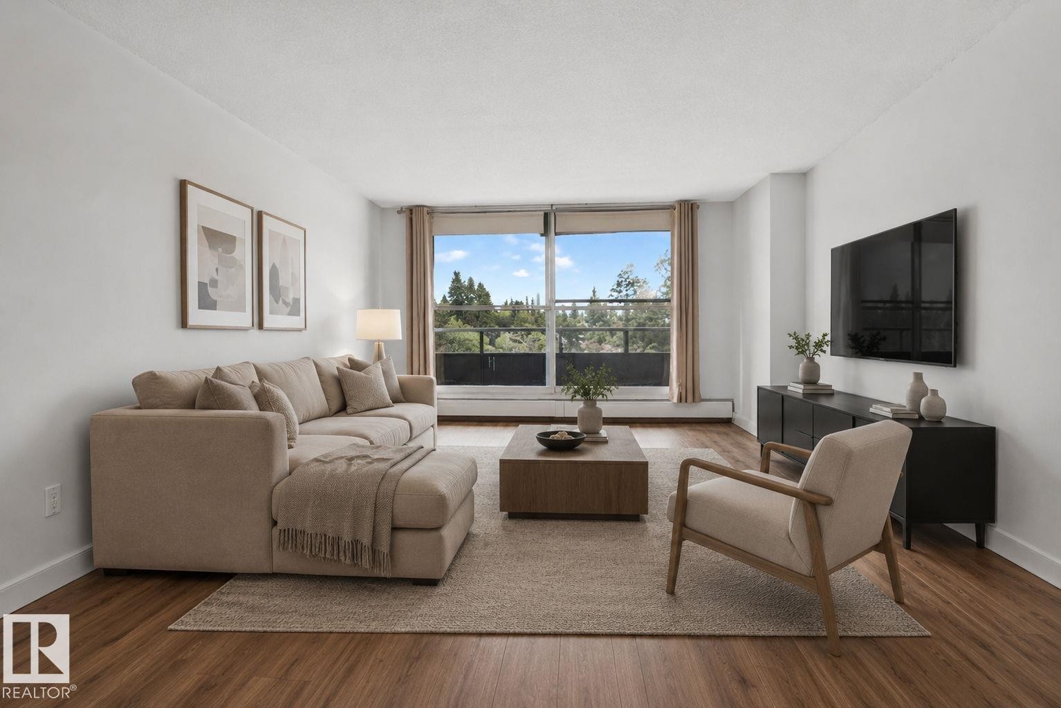 Spacious living area featuring expansive windows, wood-finish flooring, crisp white walls, and a private outdoor balcony - #412 13910 Stony Plain Rd Nw, Edmonton, AB - Indoor Photo Showing Living Room