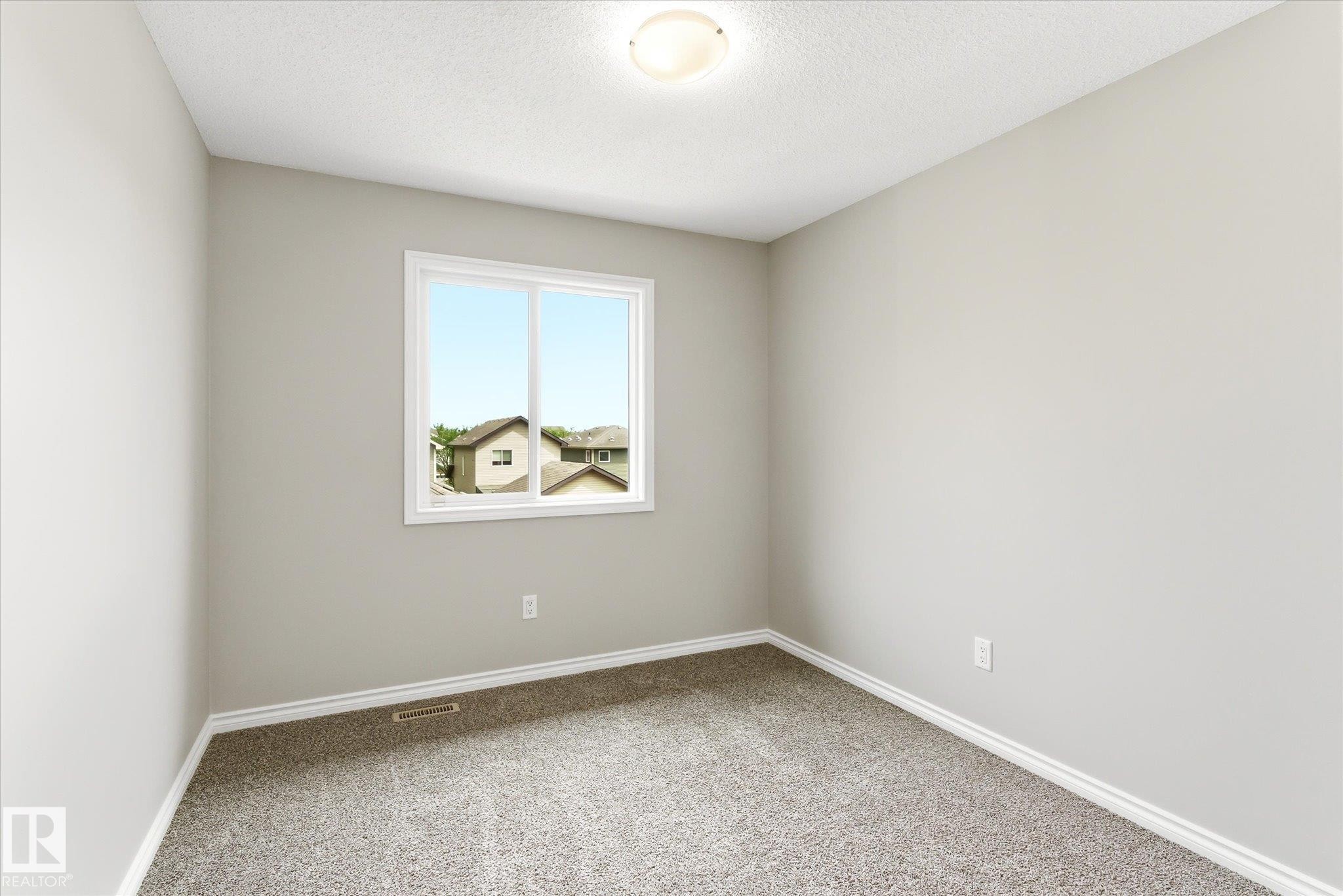 Interior room featuring light gray wall paint, white trim, and textured gray carpeting - 9039 219 Street, Edmonton, AB