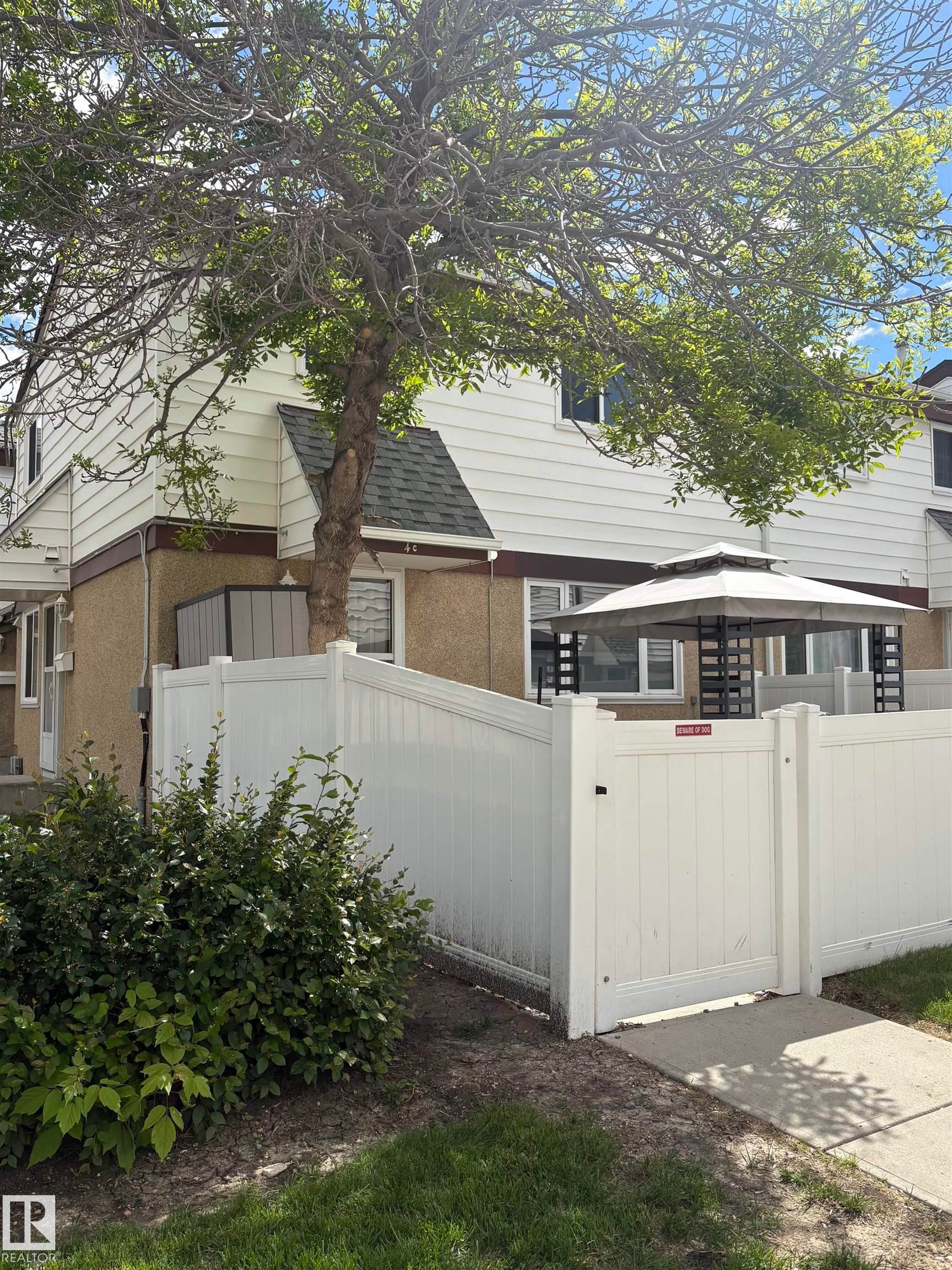 Rear exterior featuring white vinyl siding and a dark shingled roof - 4C Twin Terrace, Edmonton, AB