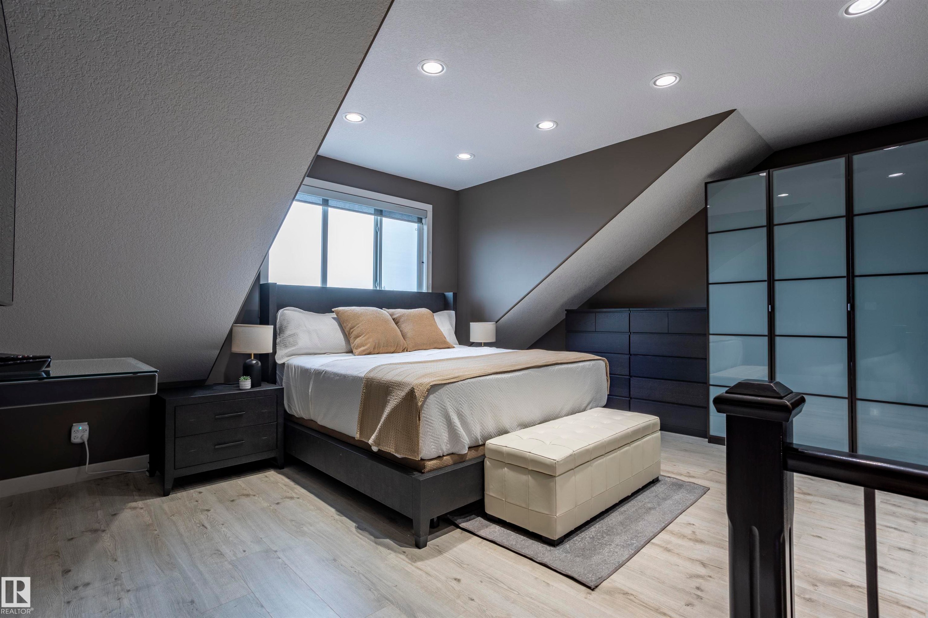 Bright room featuring recessed lighting, light wood-finish flooring, a contemporary built-in wardrobe with frosted glass panels, an integrated dresser, and a window with privacy blinds - 4949 Terwillegar Common Nw, Edmonton, AB
