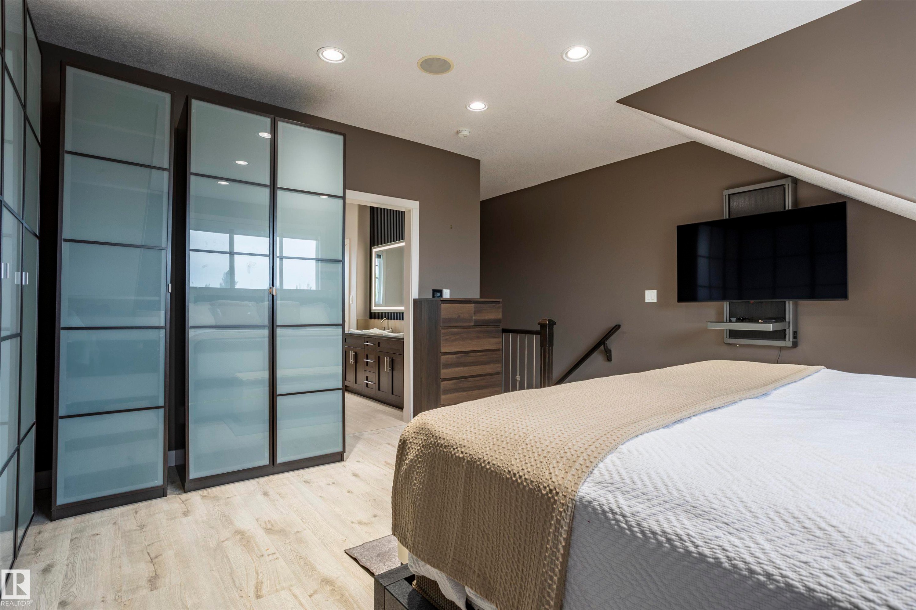 Recessed lighting illuminates wood-finish flooring - 4949 Terwillegar Common Nw, Edmonton, AB