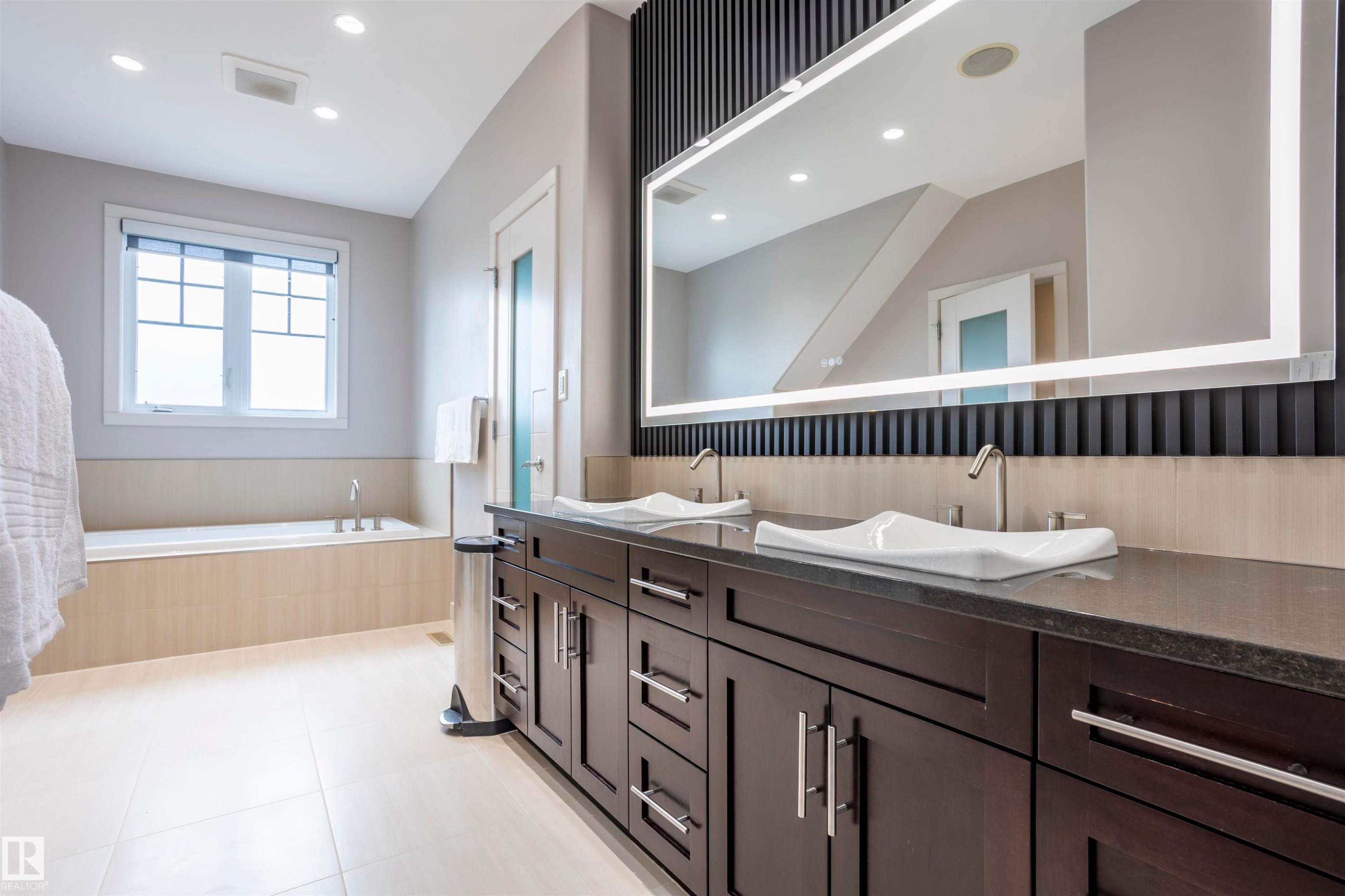 Dual vanity with dark wood cabinetry, solid surface countertop, and contemporary vessel sinks - 4949 Terwillegar Common Nw, Edmonton, AB