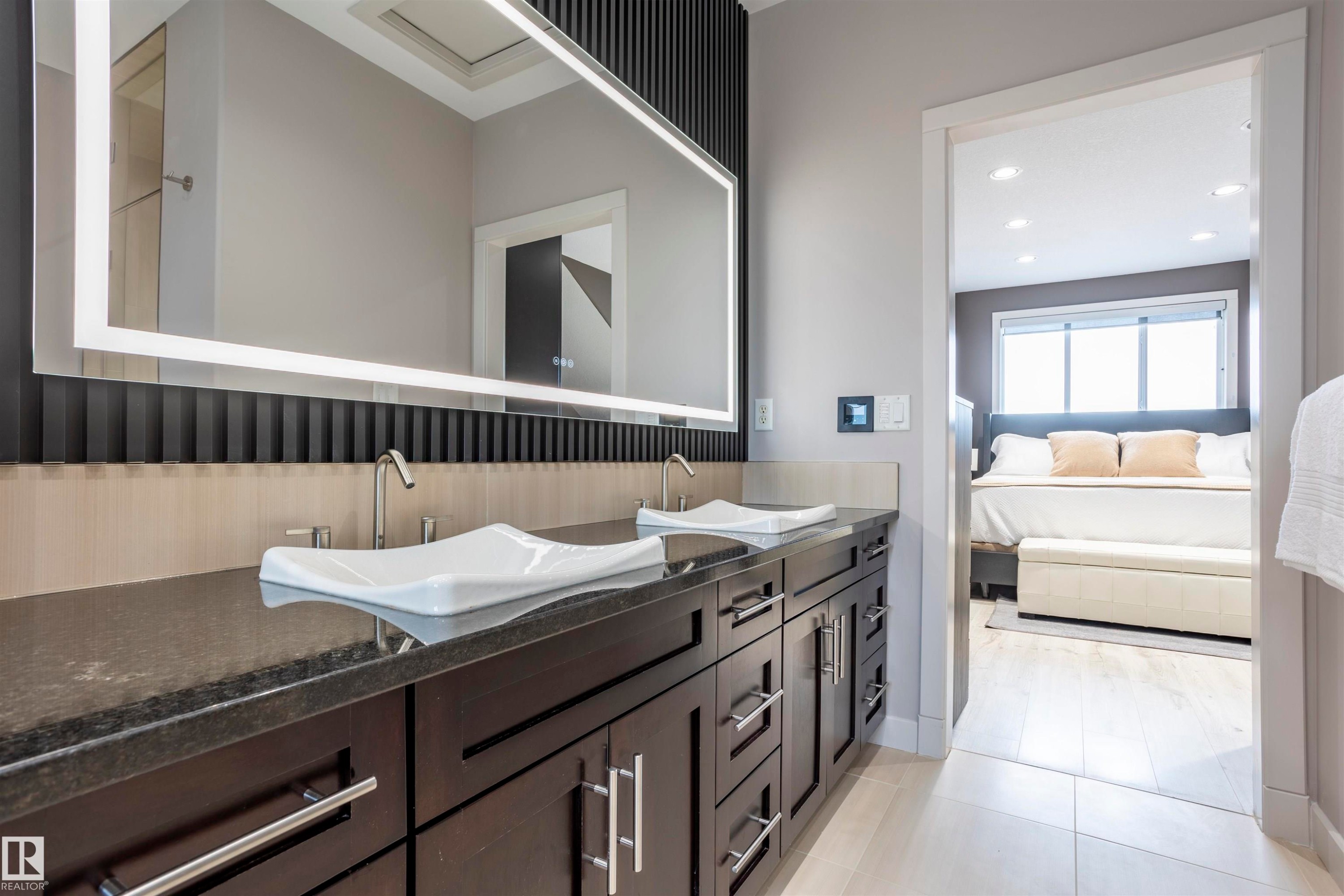 Spacious bathroom featuring a dual vanity with rectangular vessel sinks, dark wood cabinetry, and a stone countertop - 4949 Terwillegar Common Nw, Edmonton, AB