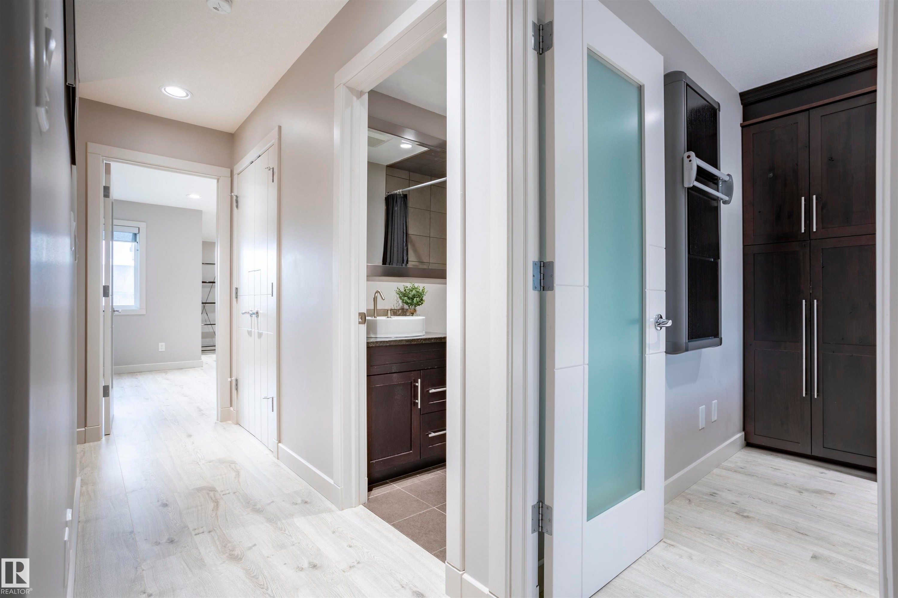 Bright hallway featuring light wood-finish flooring, recessed lighting, and white trim - 4949 Terwillegar Common Nw, Edmonton, AB
