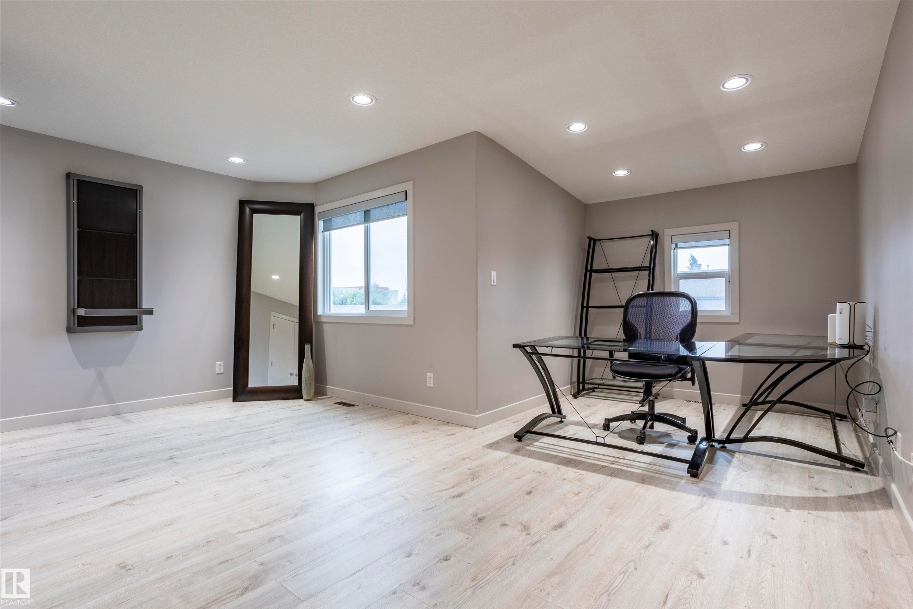 Spacious room featuring light wood-finish flooring, recessed lighting, and multiple windows with roller blinds - 4949 Terwillegar Common Nw, Edmonton, AB