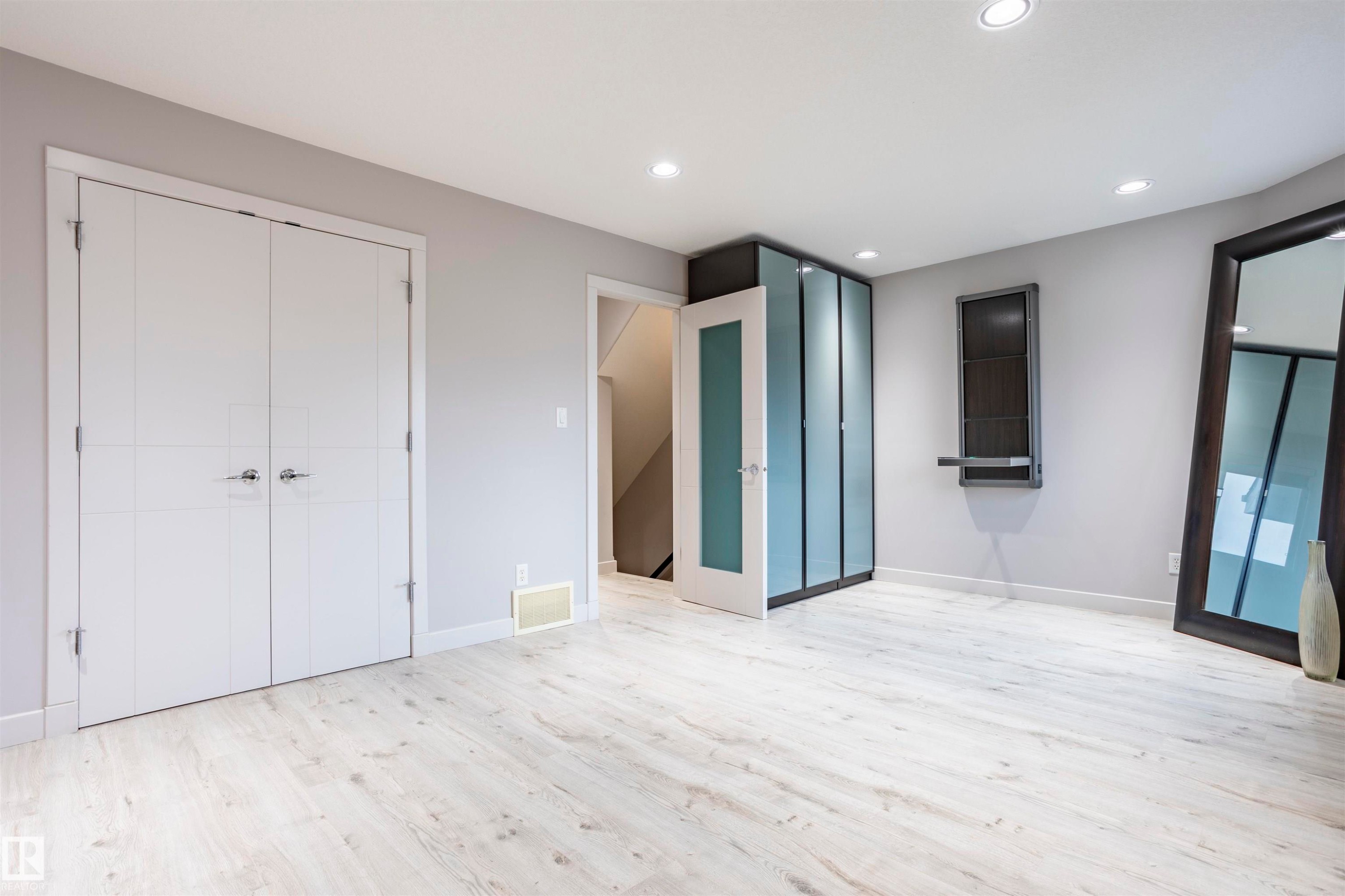 Spacious room featuring light wood-finish flooring, recessed ceiling lighting, and a neutral wall color - 4949 Terwillegar Common Nw, Edmonton, AB